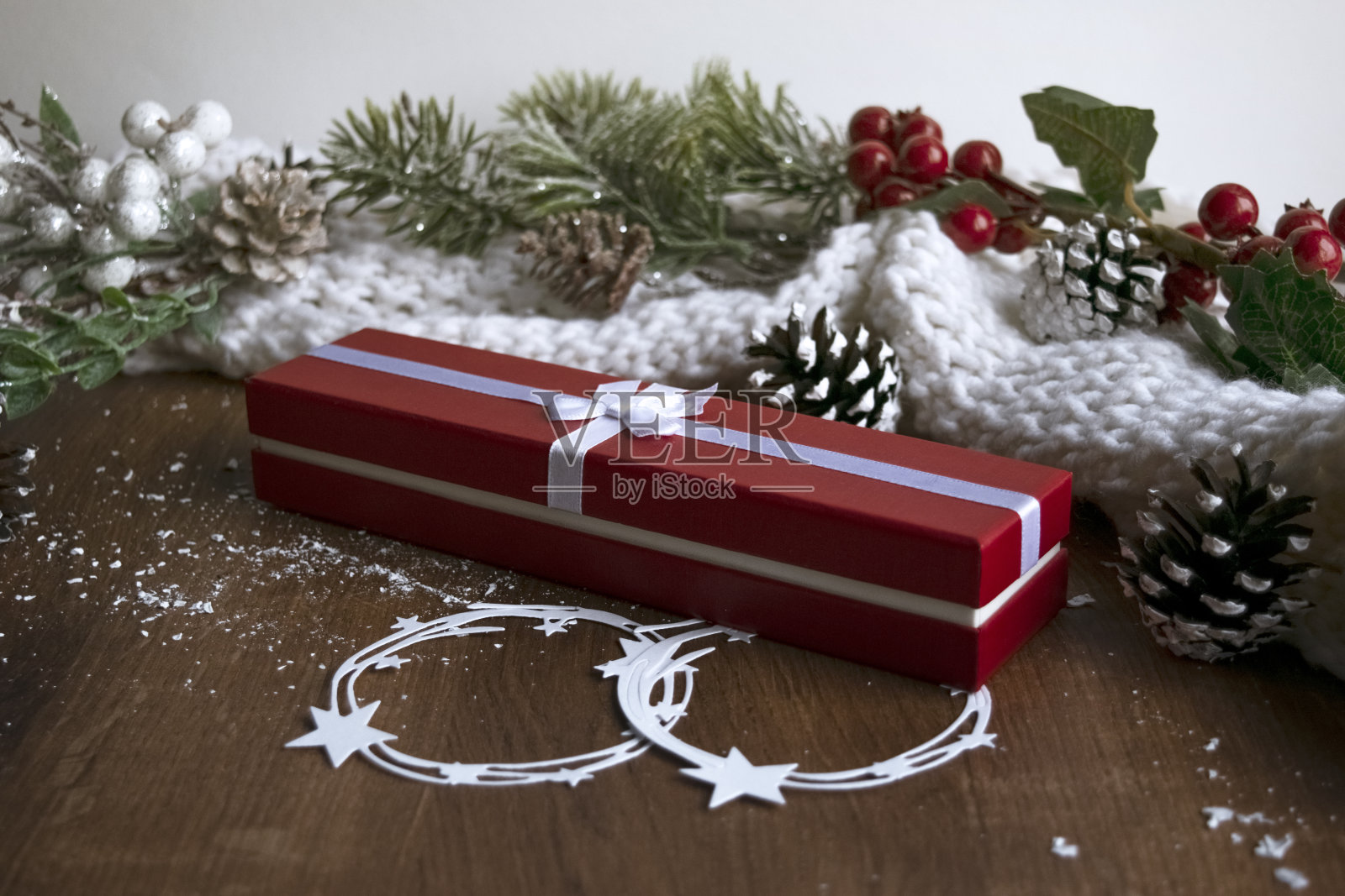 节日装饰品，圣诞蜡烛，装饰树枝和节日礼物包装在木桌上。节日的概念。圣诞节和新年的礼物。照片摄影图片