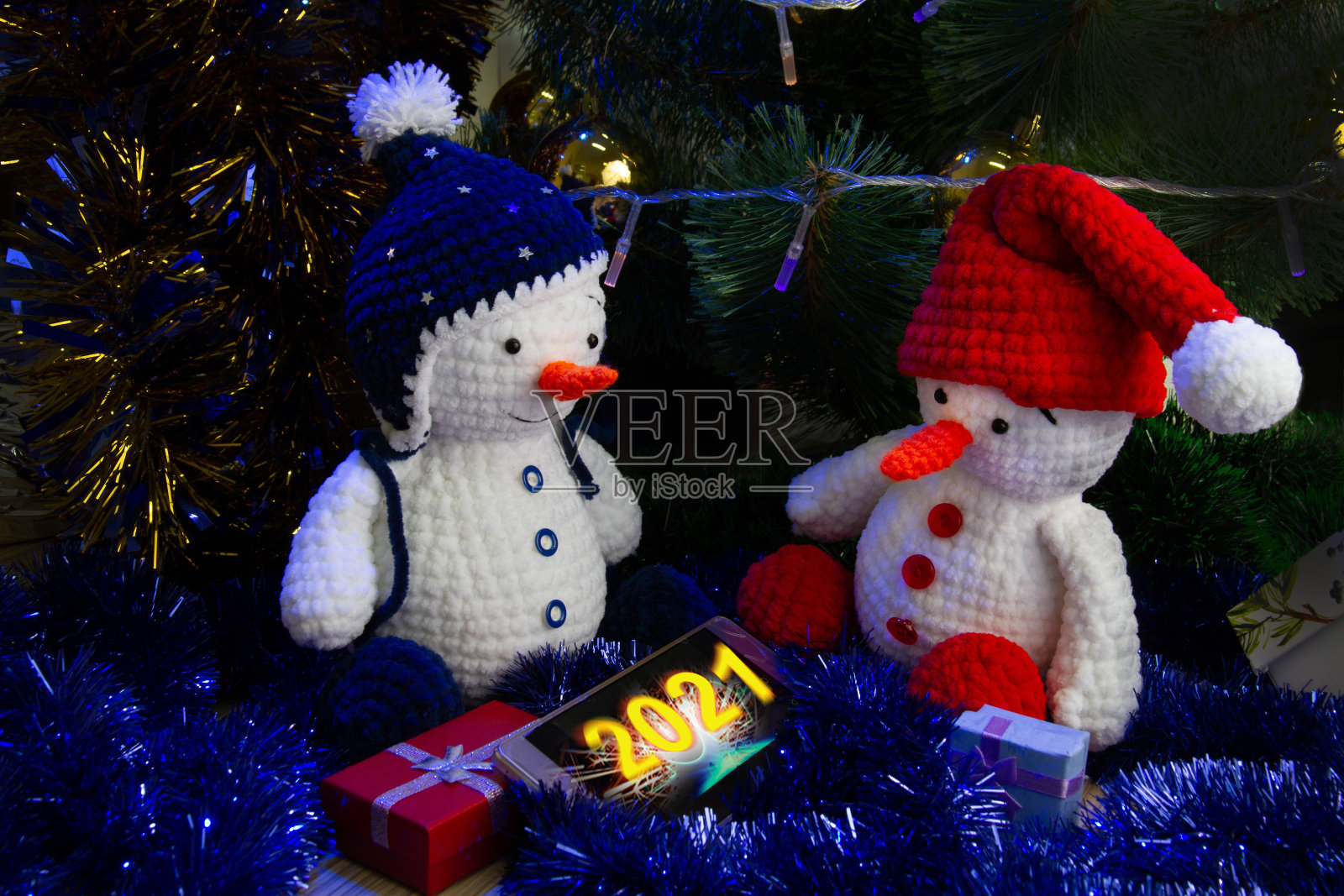 用智能手机编织雪人玩具，上面写着“2021”照片摄影图片