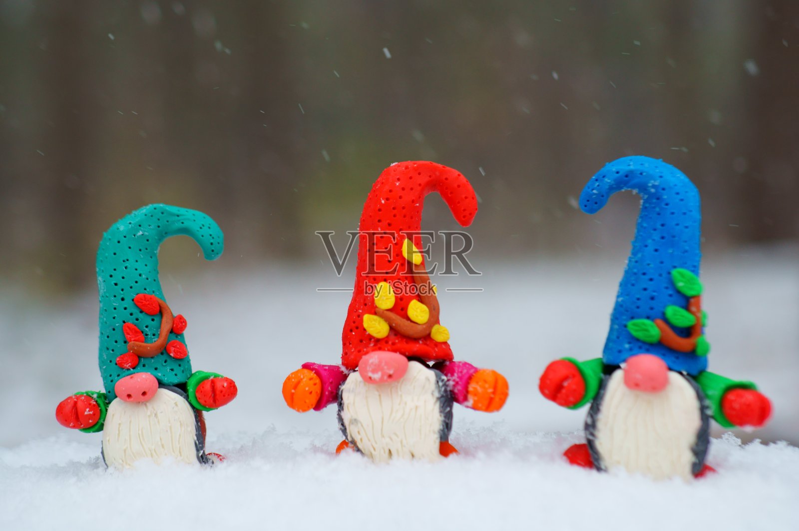 白雪背景上的三个小矮人。照片摄影图片