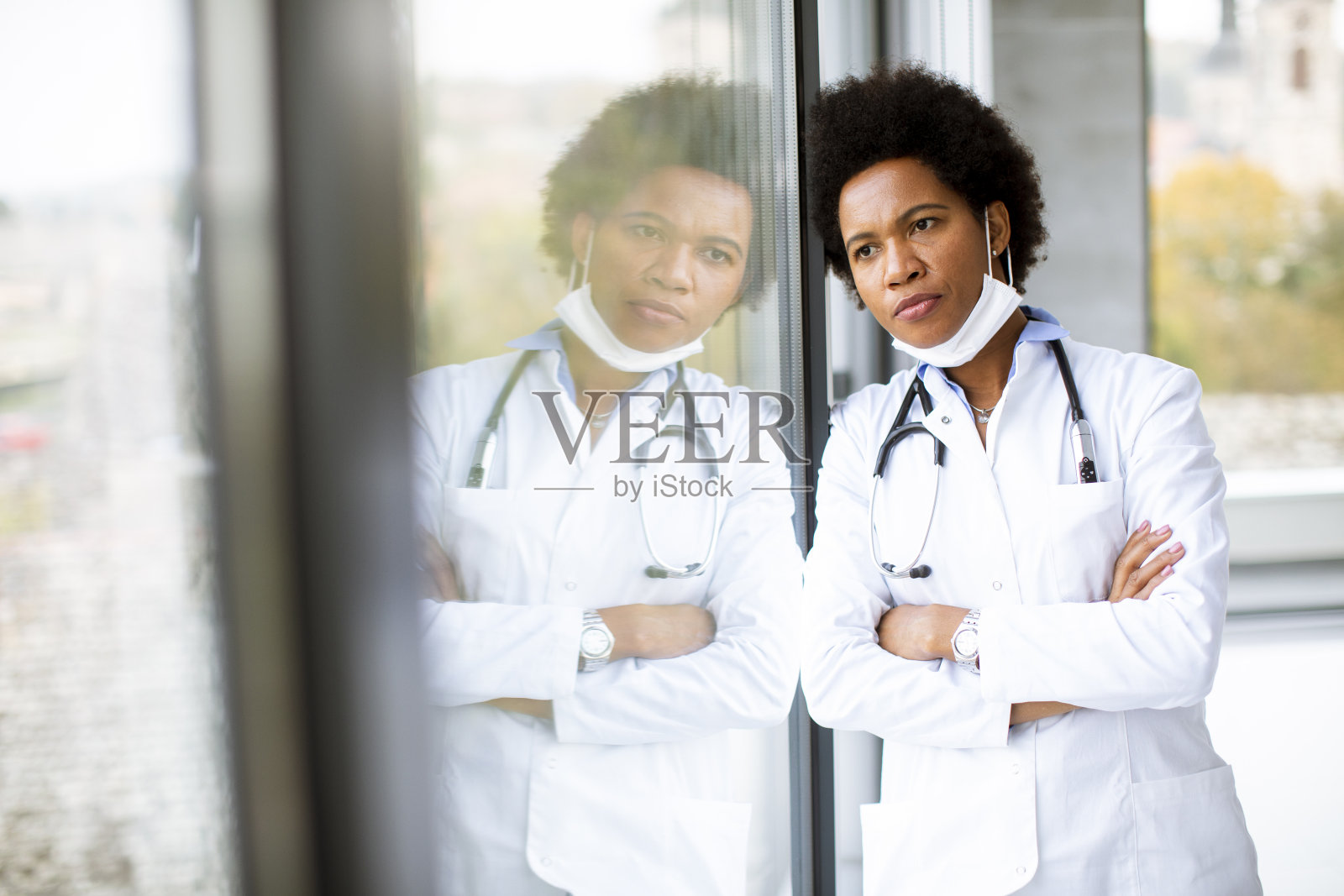 站在办公室窗口的黑人女医生，表情消极照片摄影图片