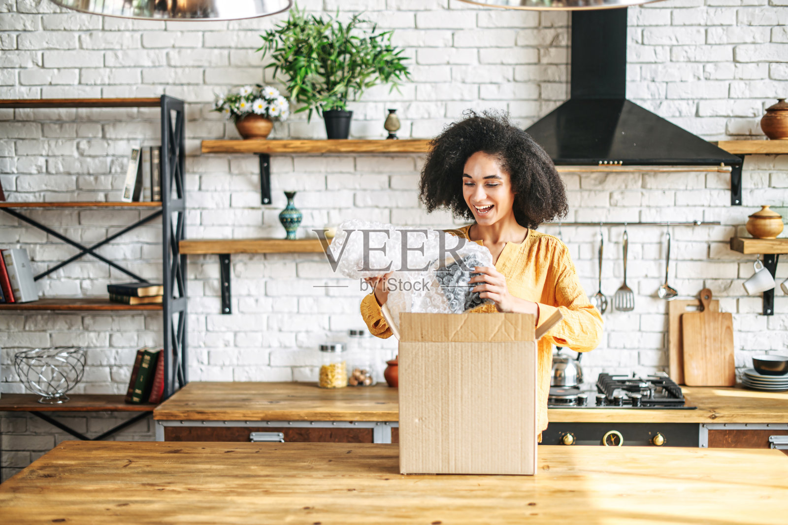 一个年轻的混血儿女孩正在打开包装盒照片摄影图片