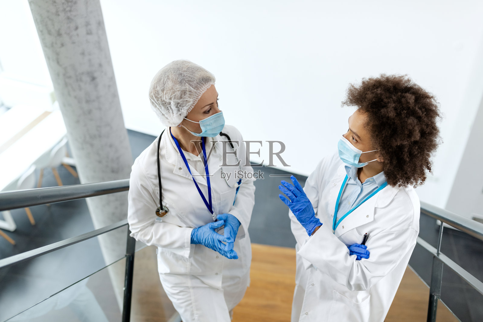 女性流行病学家在医院走廊里讨论。照片摄影图片