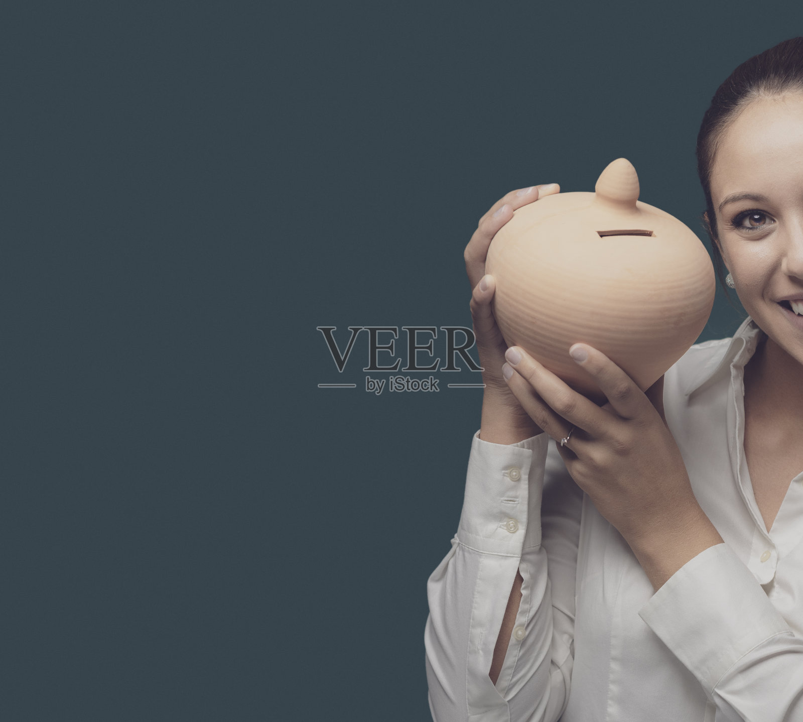 年轻的女商人拿着一个粘土钱箱照片摄影图片