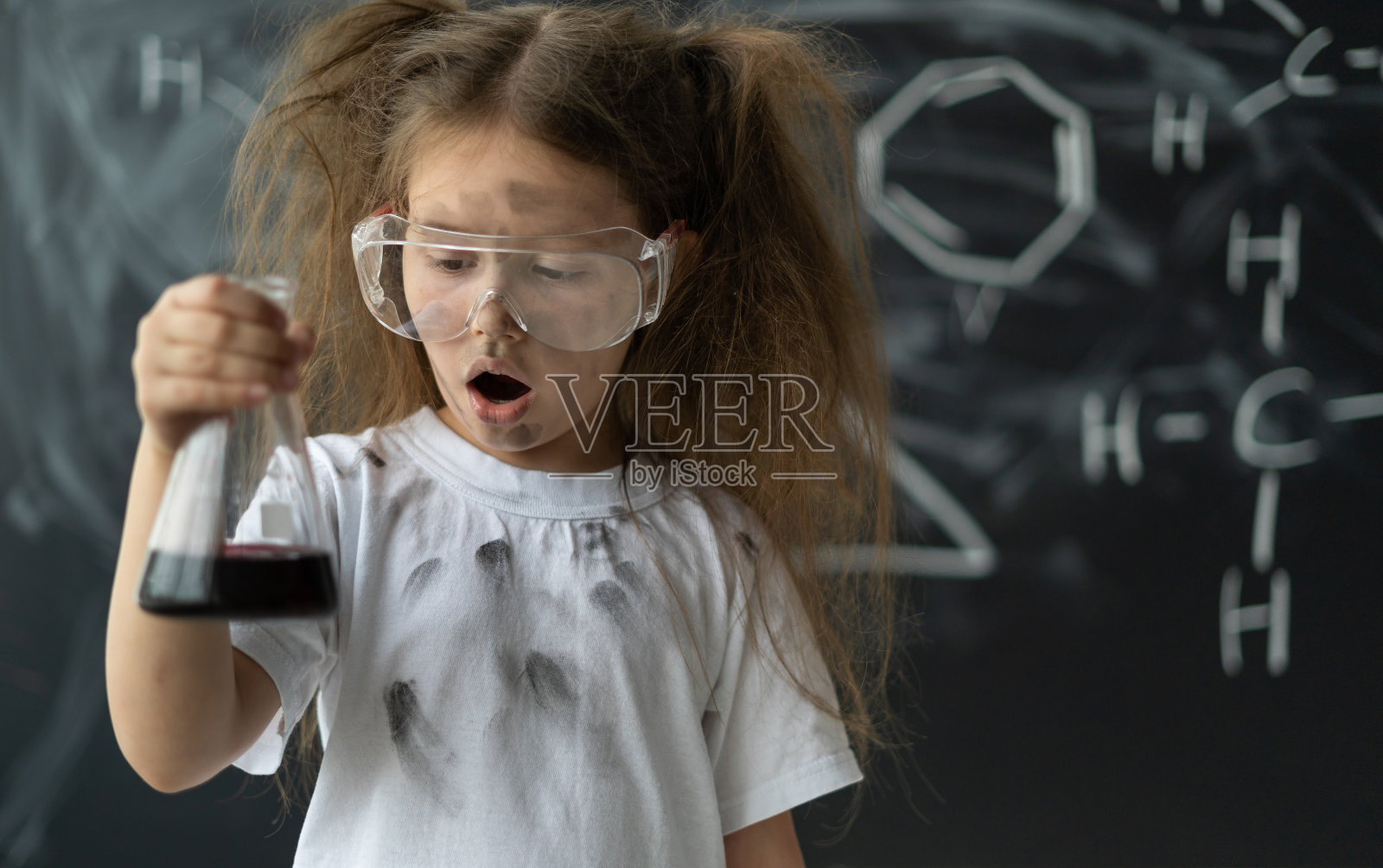 小女孩在化学课上做实验。在混合爆炸。脸上露出惊讶的表情。文本。照片摄影图片