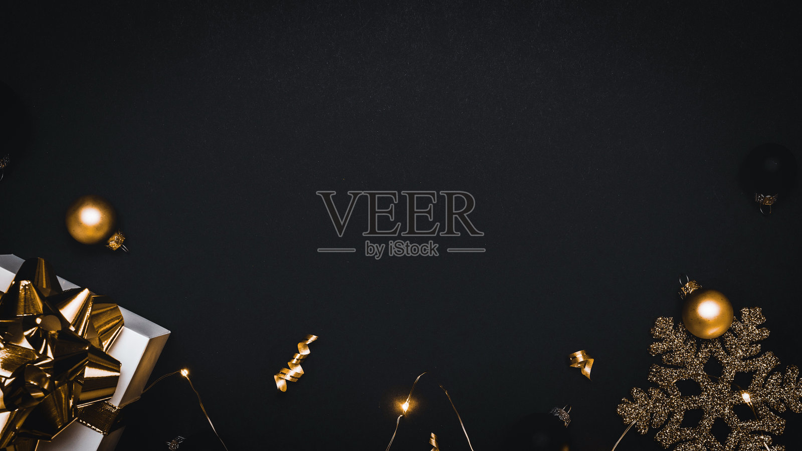 寒假快乐。白色礼物与金色蝴蝶结，金球和闪闪发光的花环在圣诞节装饰在贺卡的黑色背景。副本的空间。寒假，新年。照片摄影图片