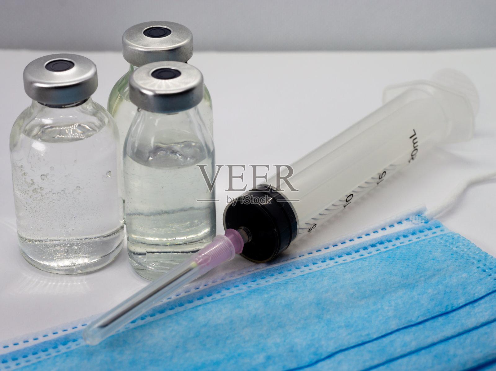 疫苗瓶，注射器和蓝色医用口罩照片摄影图片