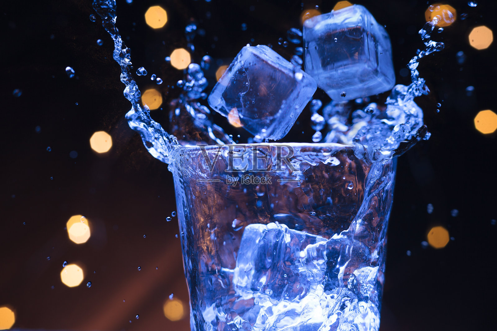 冰溅到一杯水里照片摄影图片
