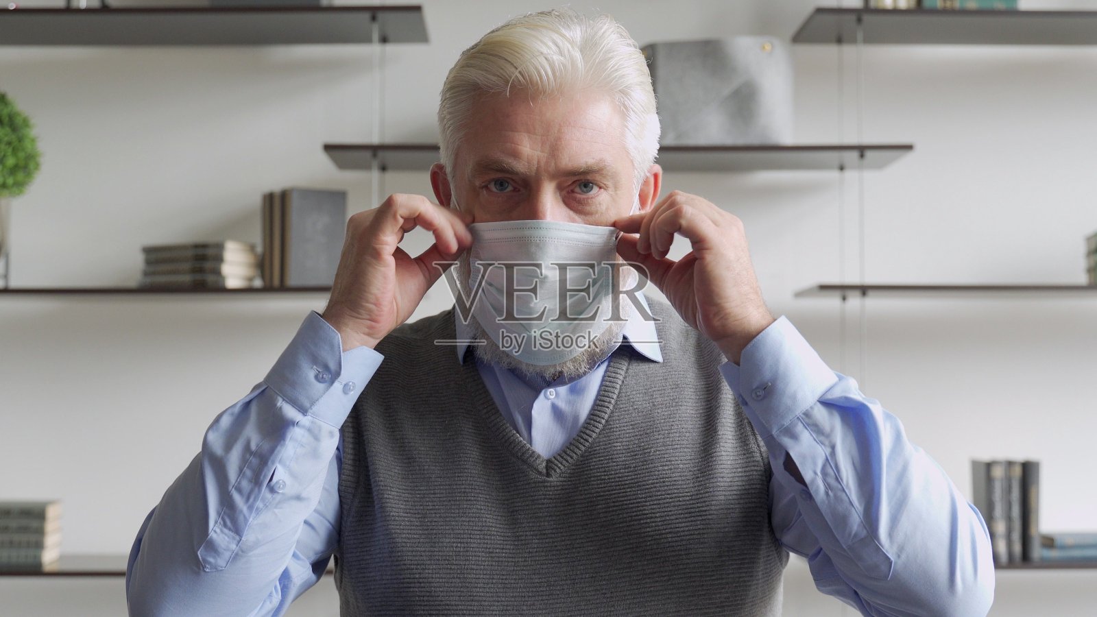 特写镜头:一位老人戴着医用口罩，以保护自己免受冠状病毒大流行的伤害照片摄影图片