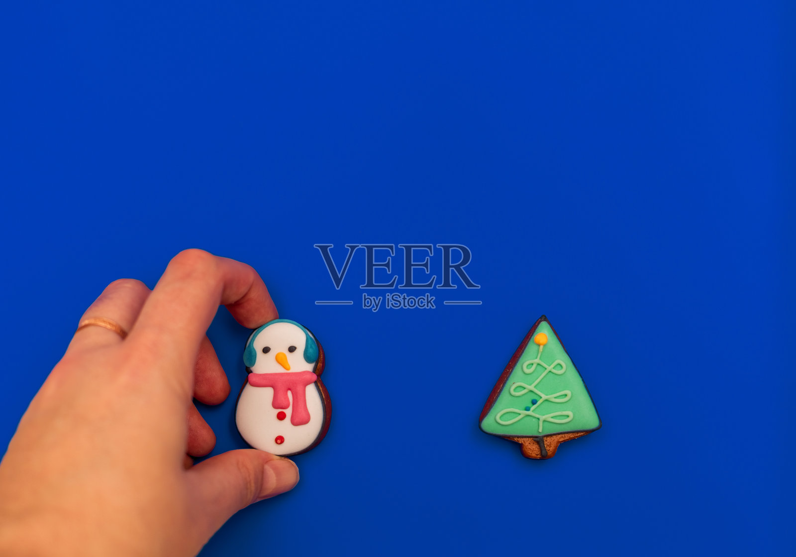 圣诞组成。姜饼饼干的形式的雪人和圣诞树在蓝色的背景。平铺，拷贝空间，俯视图。新2021年。照片摄影图片