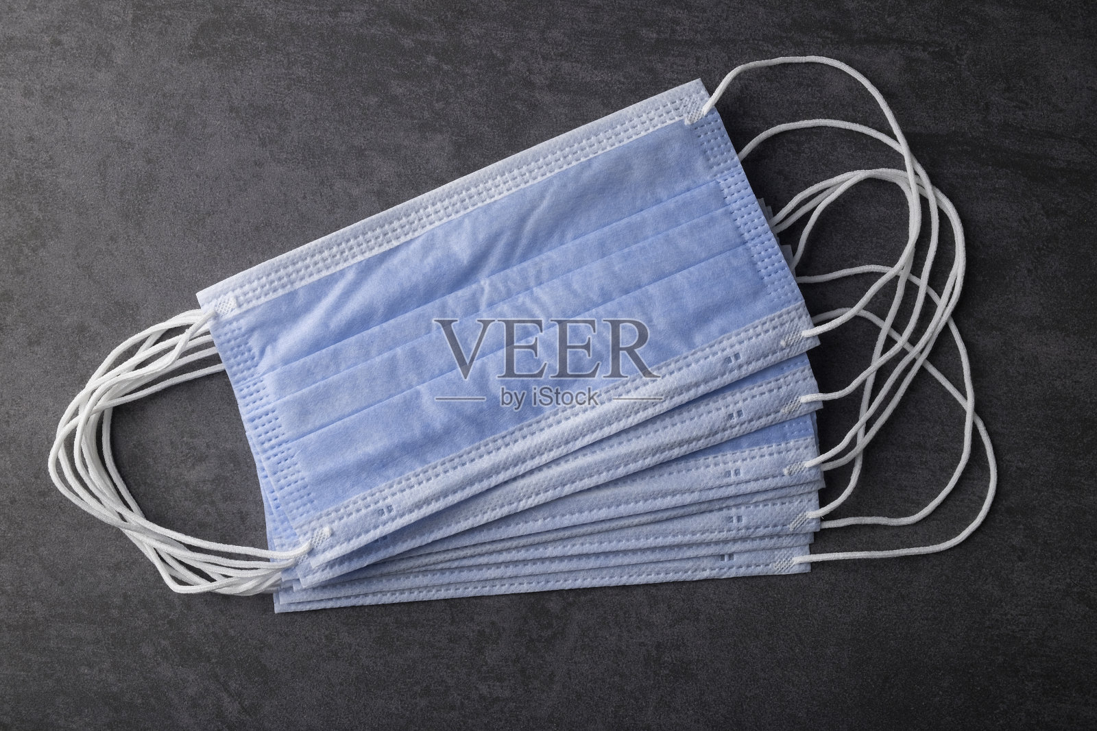 黑色背景的蓝色医用口罩照片摄影图片