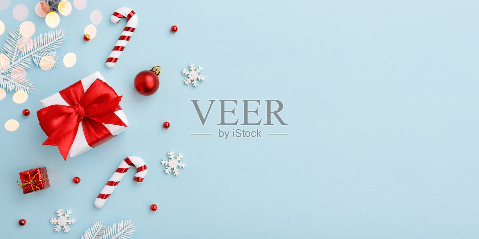 圣诞礼盒与红色蝴蝶结和装饰在柔和的蓝色背景照片摄影图片