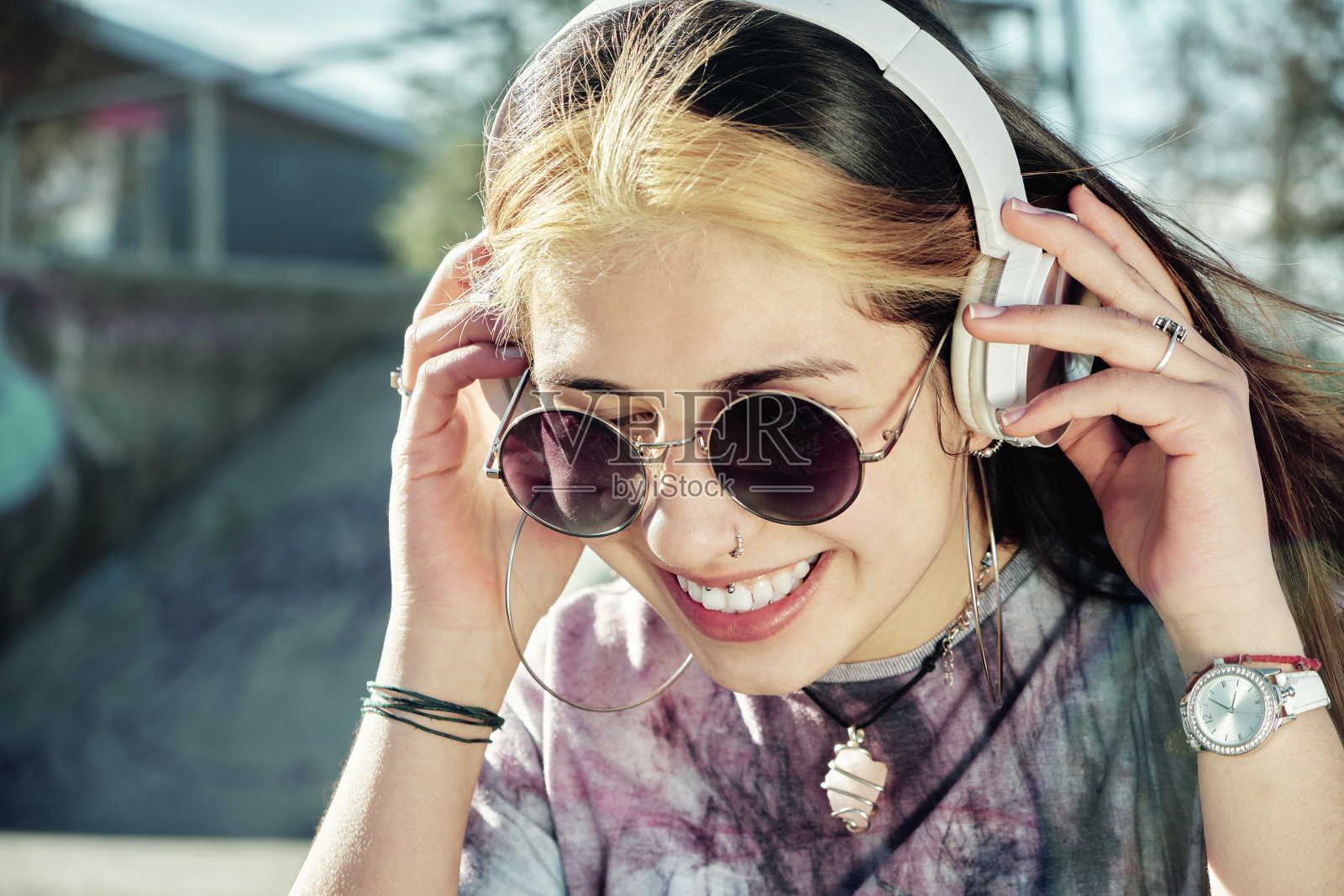 一个欢快时尚的年轻女子戴着耳机听音乐的肖像照片摄影图片