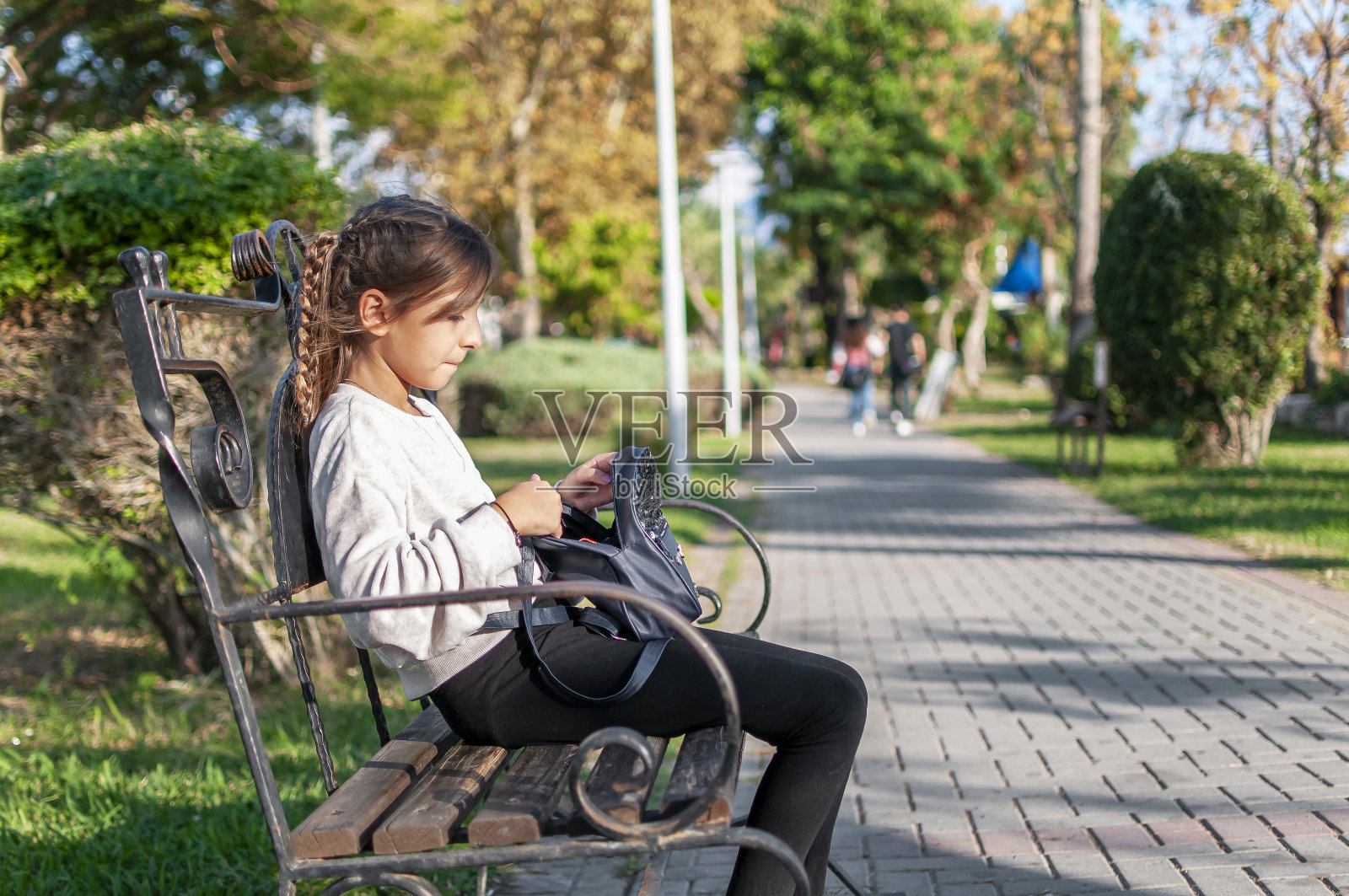 可爱的女孩在长凳上休息照片摄影图片