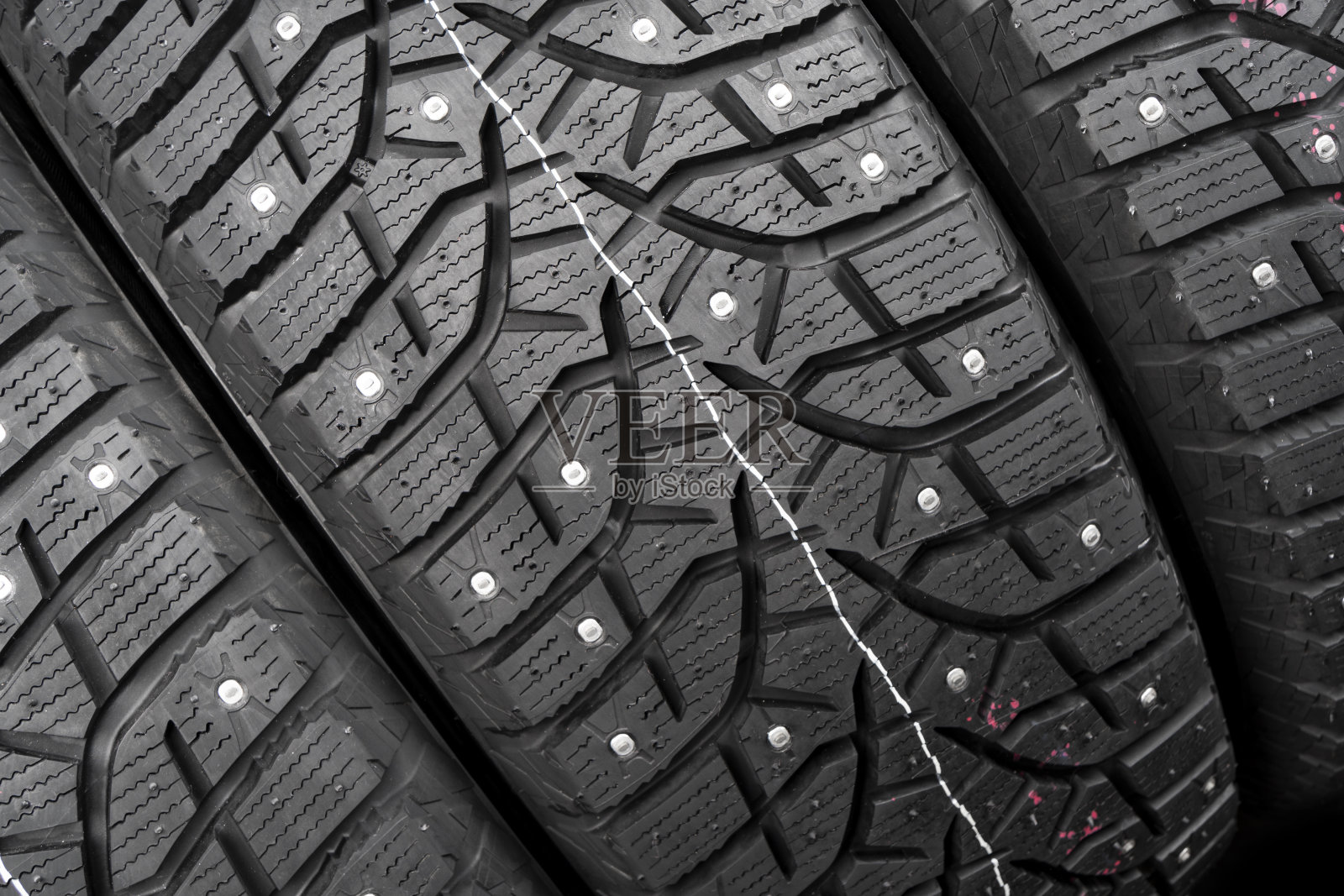 冬季镶嵌轮胎。冬季汽车轮胎背景。轮胎堆栈的背景。轮胎保护关闭。广场强大的峰值。黑色的冬用轮胎轮廓。汽车轮胎排成一排照片摄影图片