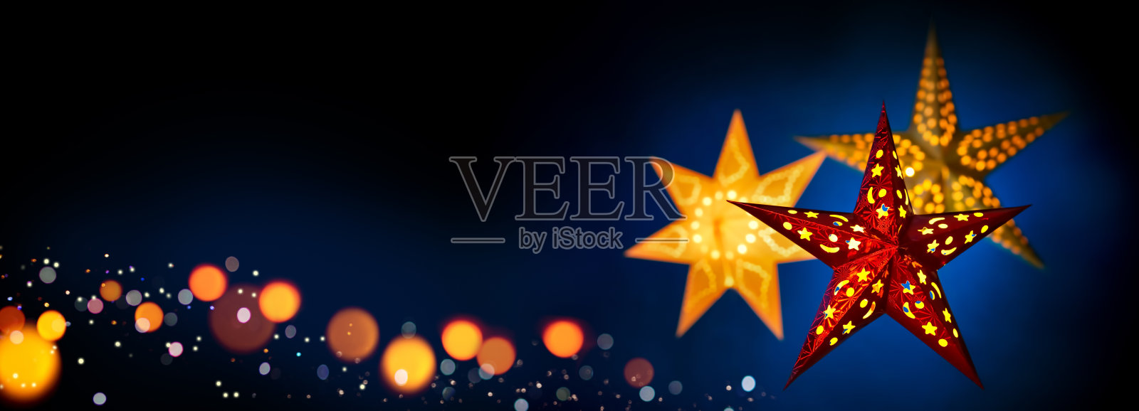 深蓝色和黑色背景的圣诞彩灯照片摄影图片