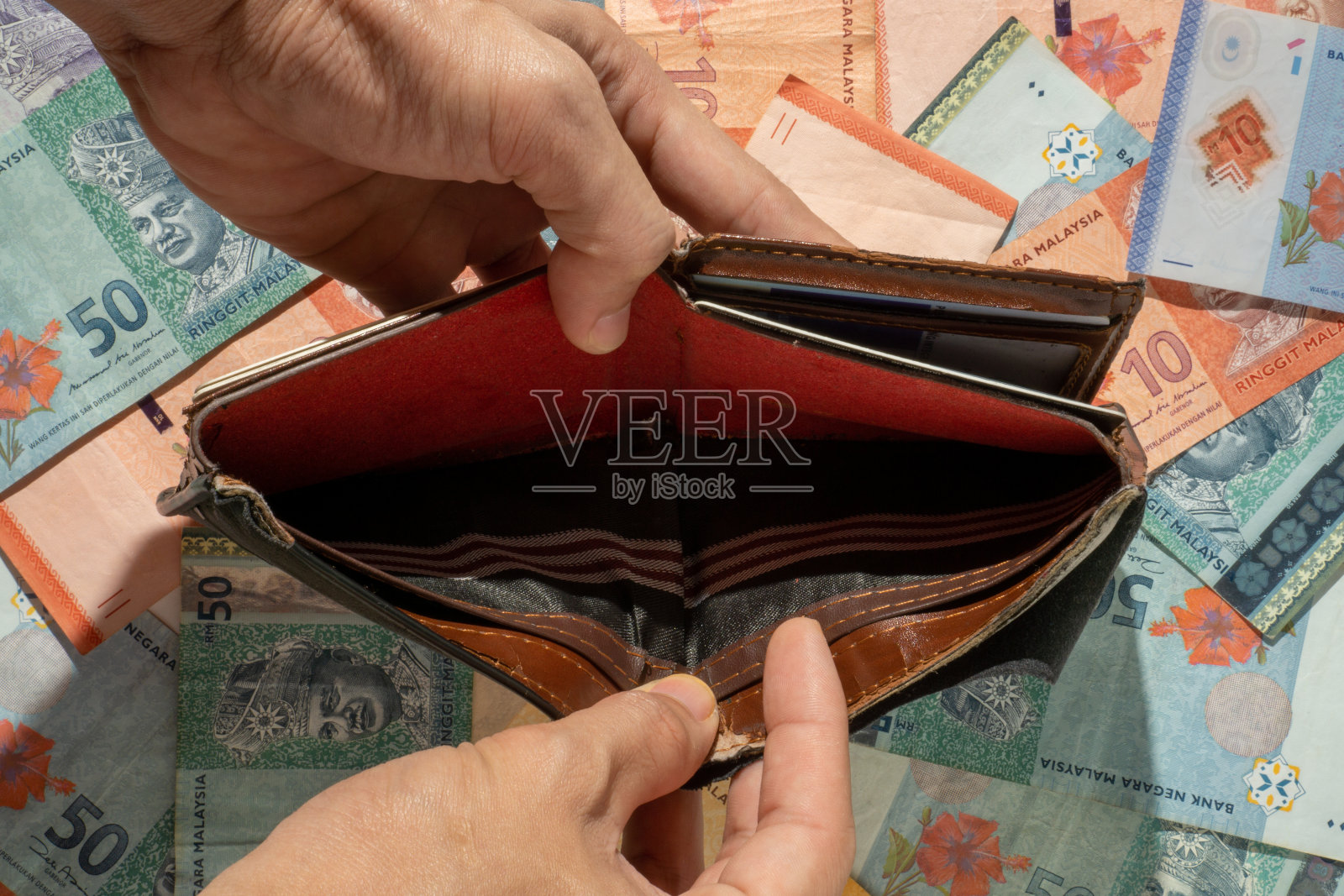 一名男子展示钞票背景上的空钱包照片摄影图片