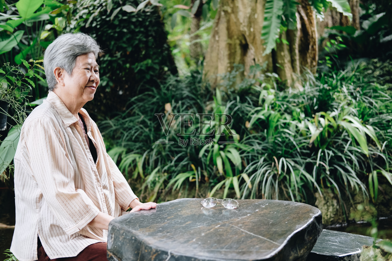 年老的女人在花园里休息。上了年纪的女性在户外放松。高级休闲生活方式照片摄影图片