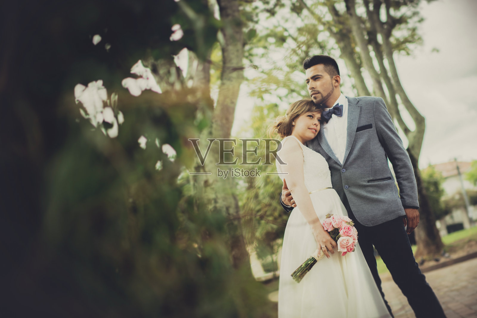 一对新婚夫妇在美丽的自然公园里拥抱在一起照片摄影图片