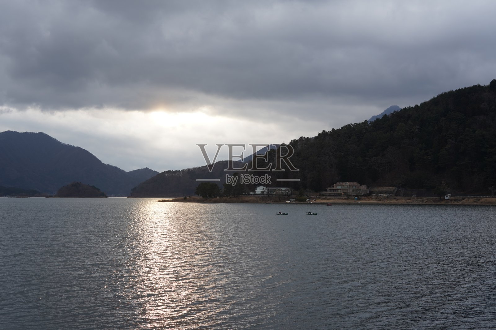 多云的日子里，山和湖边的夕阳景色照片摄影图片