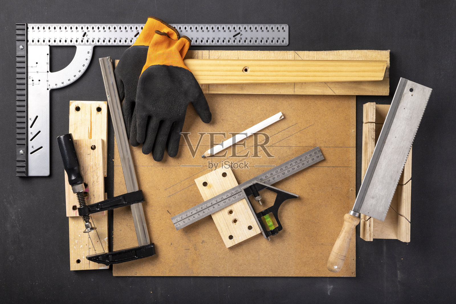 家庭木工车间里的一张桌子。木匠架子上的木工配件。黑暗的背景。照片摄影图片