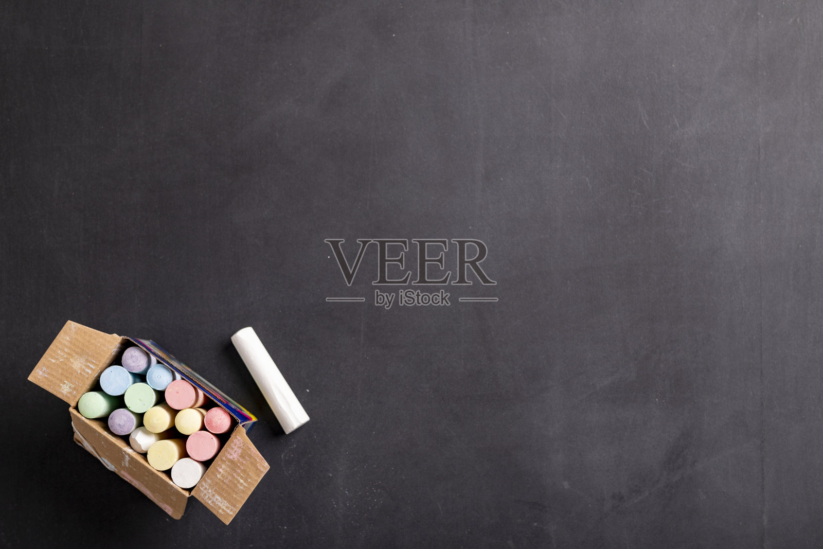 用粉笔在黑板上写字和画画。在学校保存课程内容的附件。黑暗的背景。照片摄影图片