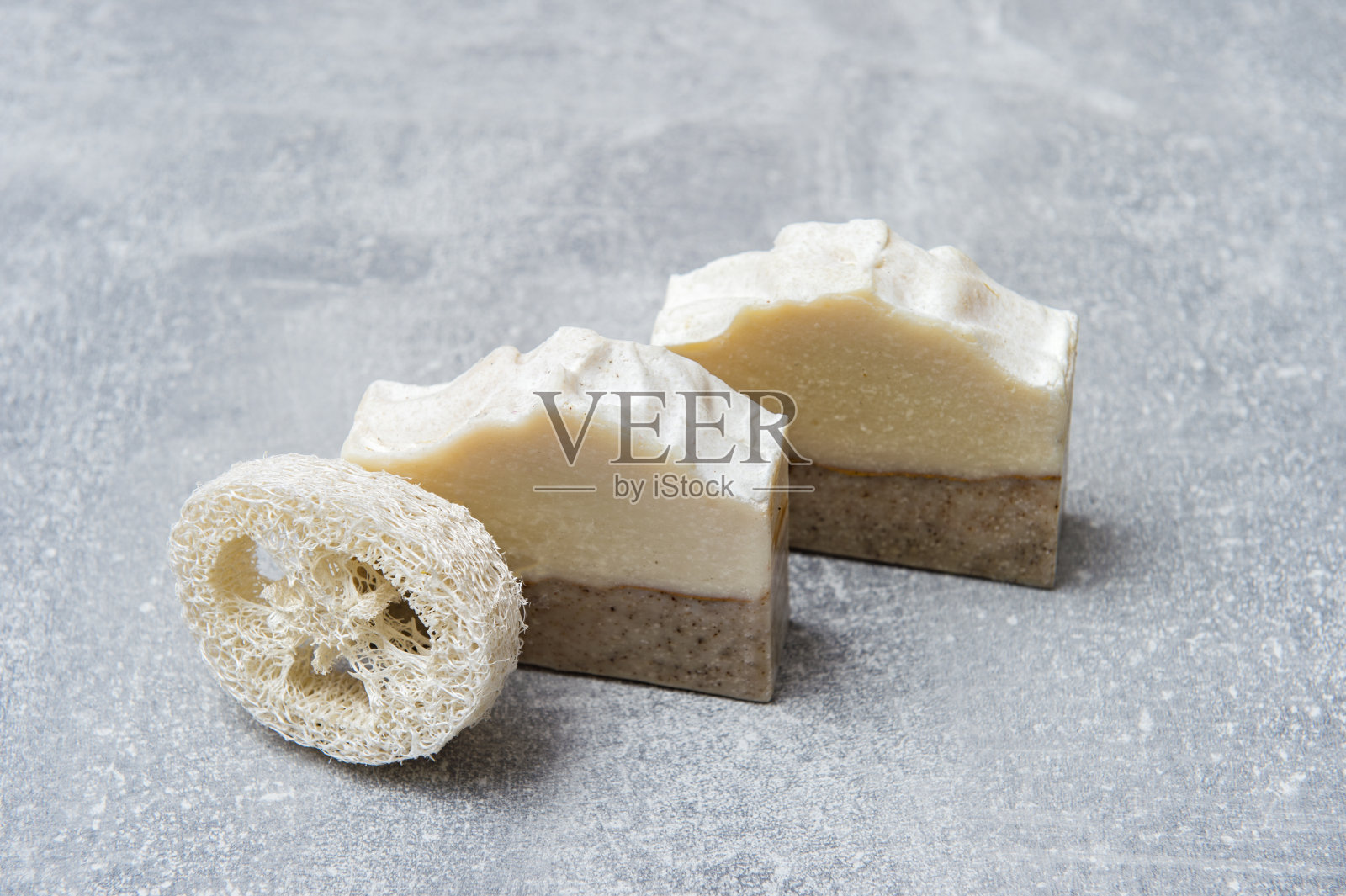 灰色背景上的手工肥皂和丝瓜海绵。生态生活方式的概念。“n”n照片摄影图片