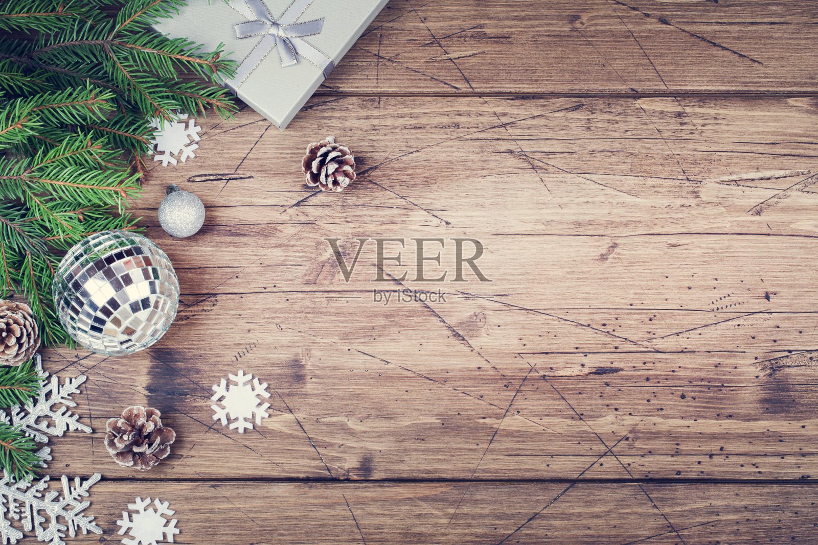 冷杉枝，礼物，锥形，雪花和迪斯科球在棕色的木制背景，俯视图拷贝空间。圣诞节和新年的背景照片摄影图片