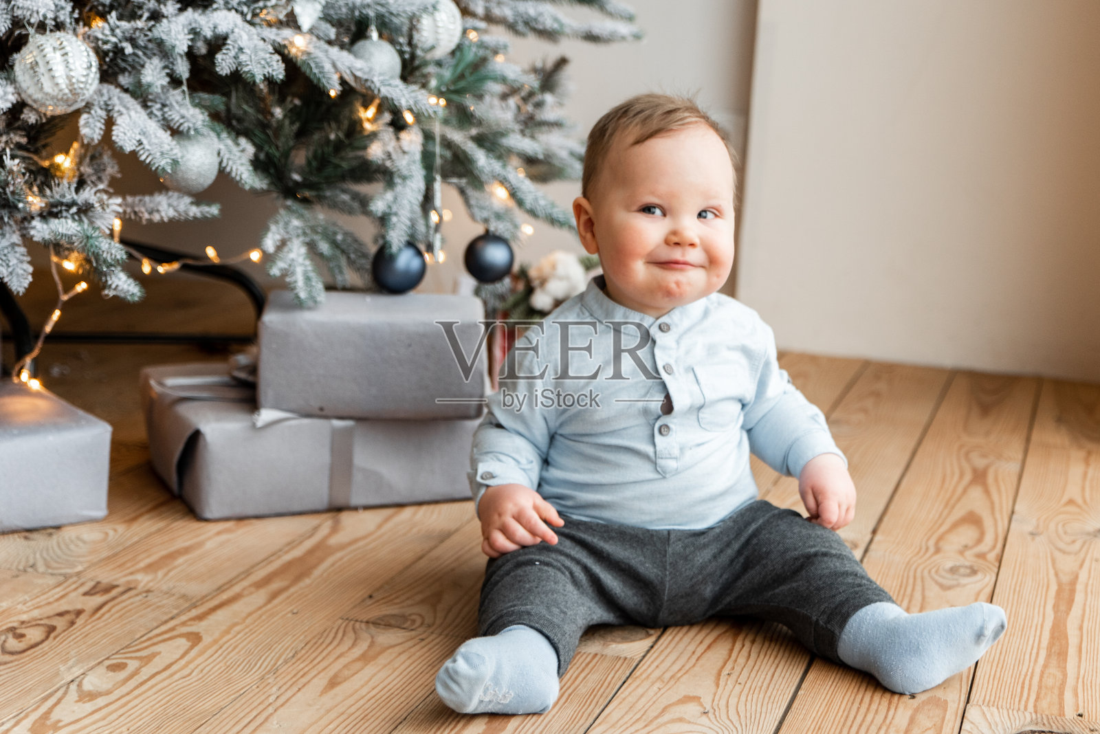 一个可爱的小男孩在圣诞树旁照片摄影图片