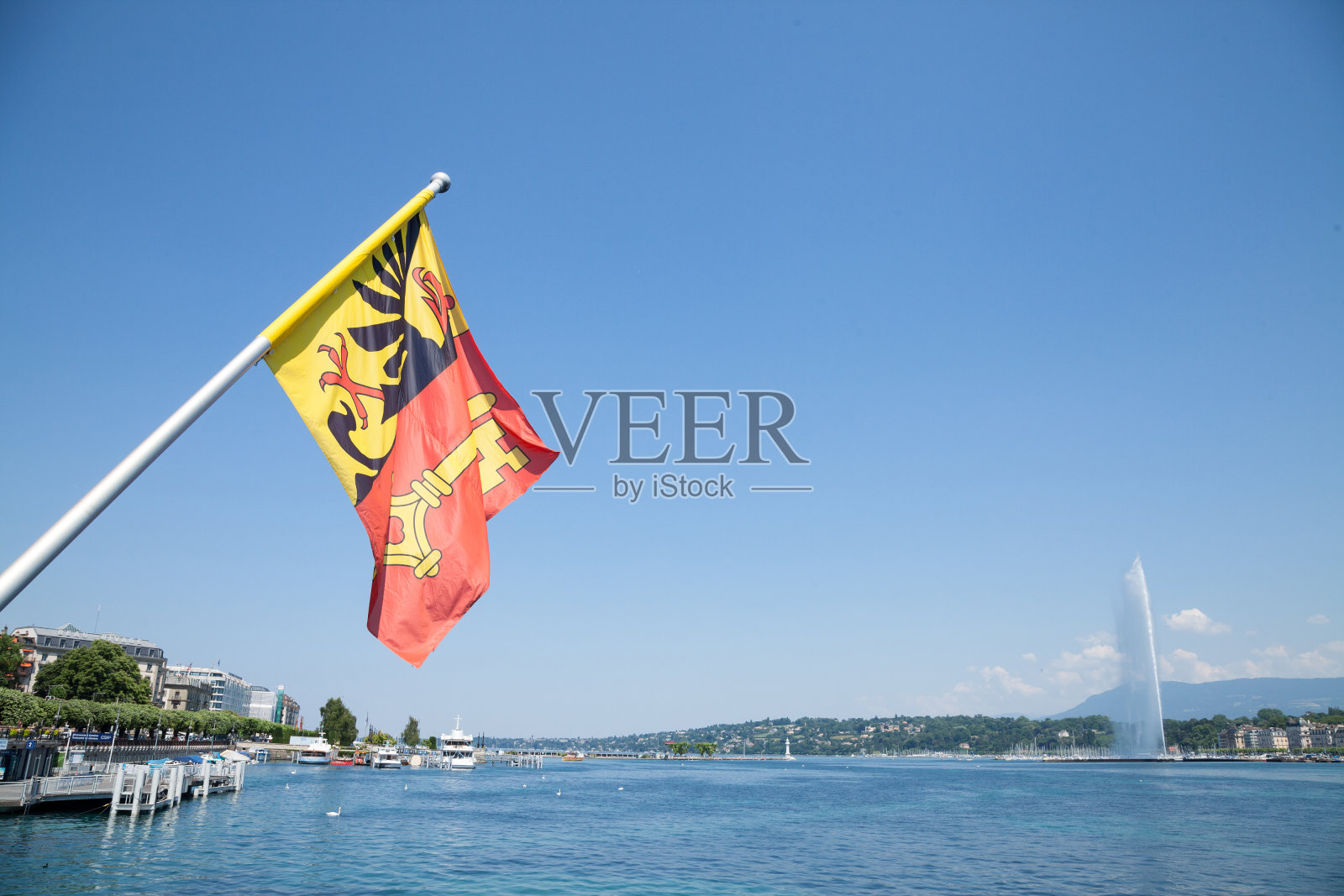 位于日内瓦市中心莱曼湖上的日内瓦Canton旗。标志性的Jet d'Eau(水射流)可以在背景中看到。日内瓦是瑞士的主要城市之一。照片摄影图片