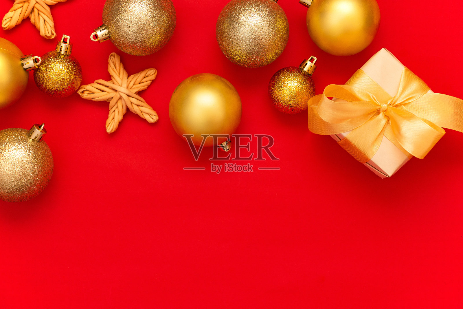 金色的圣诞球装饰和冷杉枝在红色的背景与复制空间。新年组成。平躺，俯视图。简约的风格。照片摄影图片