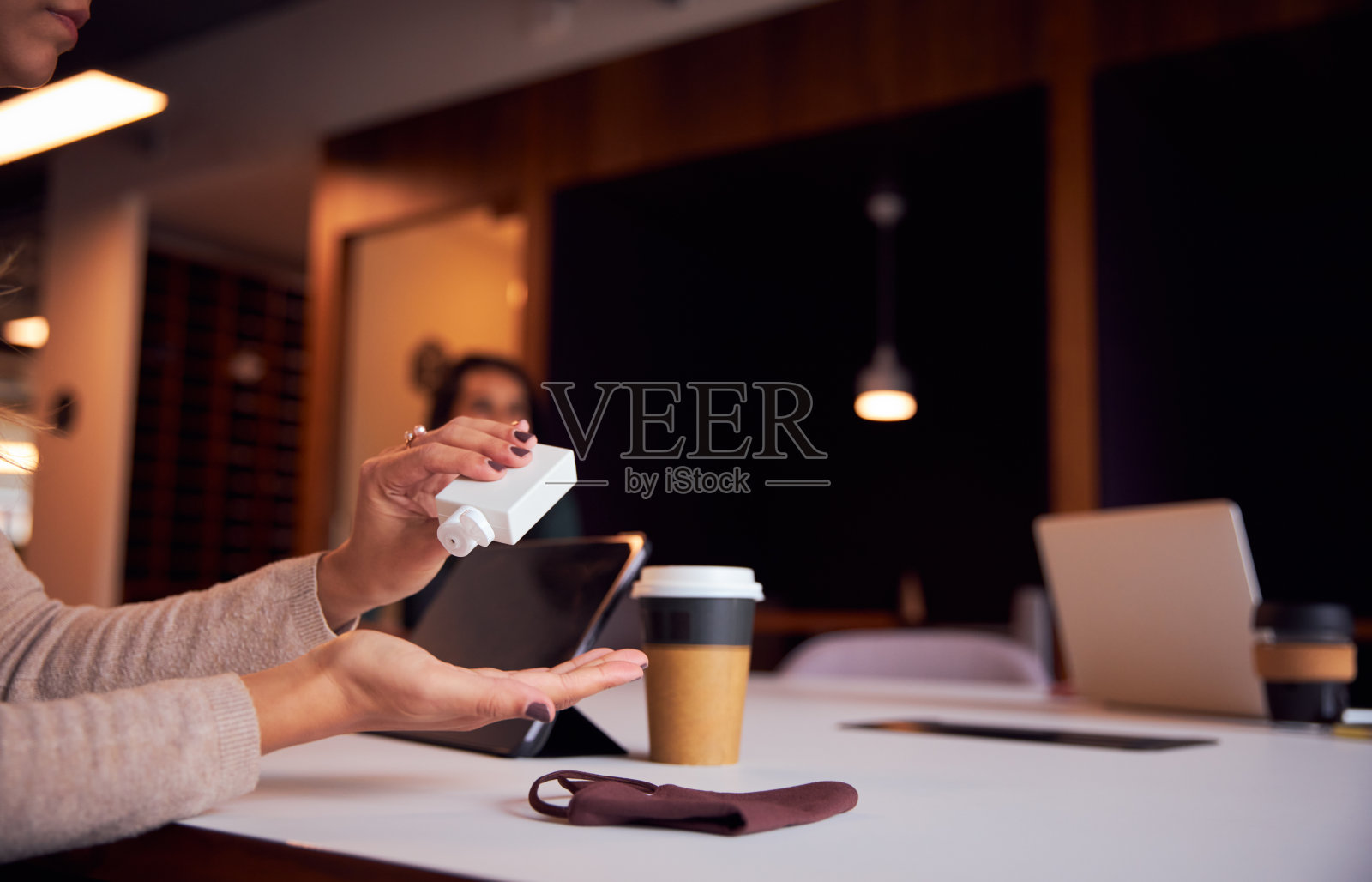 职场女性在健康大流行期间在办公室的社交会议上使用洗手液照片摄影图片