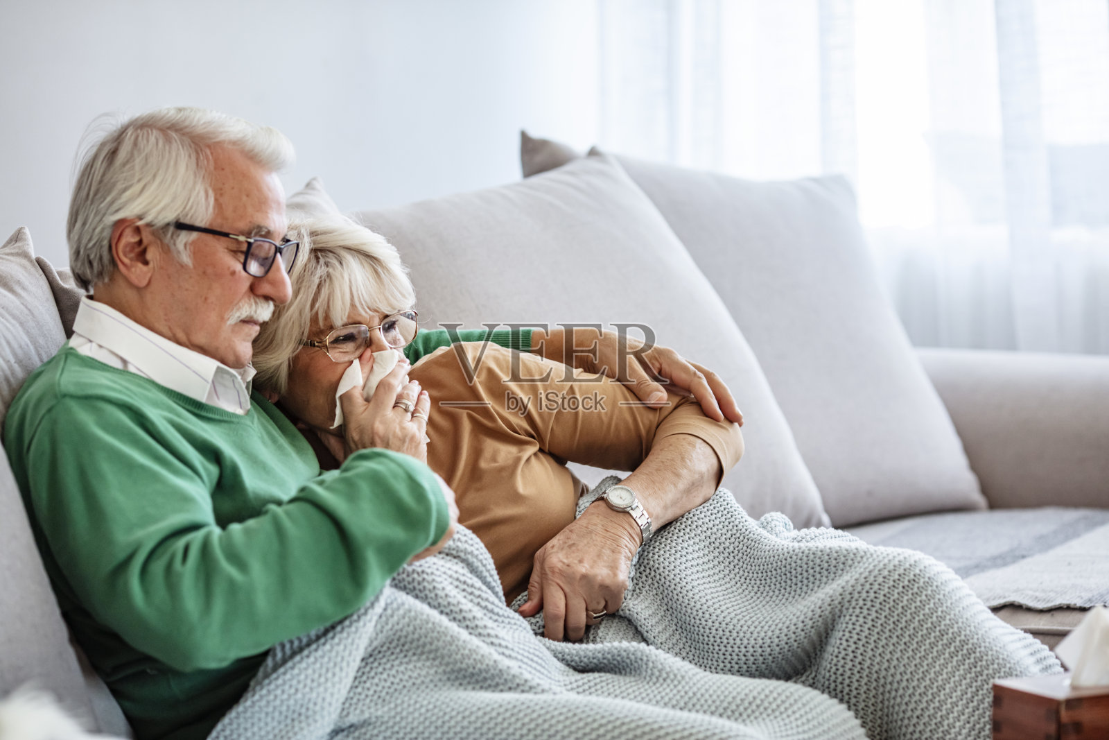 老人在妻子感冒时安慰她。照片摄影图片