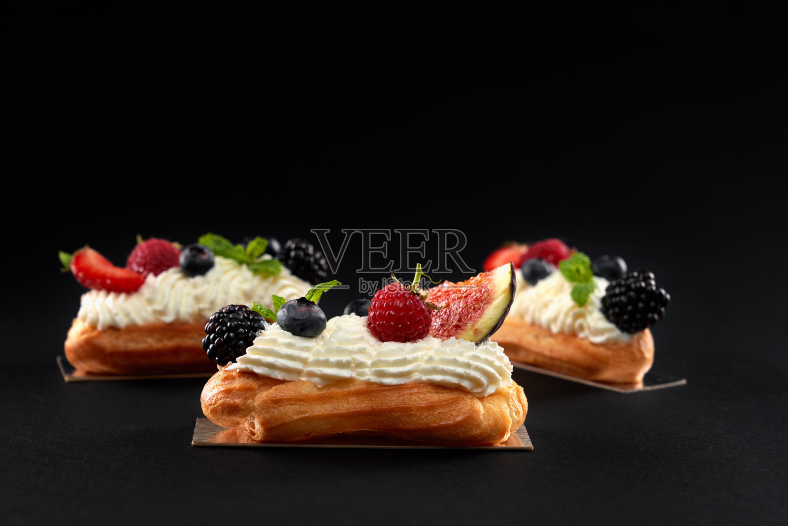 用奶油和浆果自制泡芙条。照片摄影图片