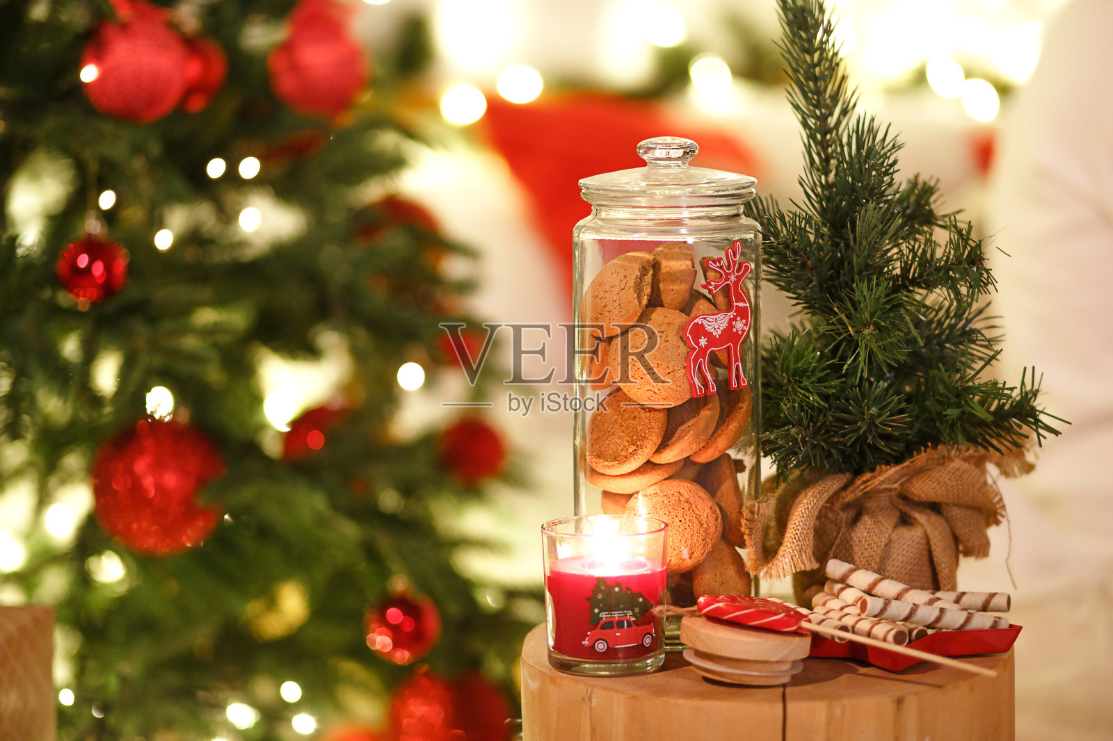 红色的圣诞树上装饰着彩灯和花环。照片摄影图片