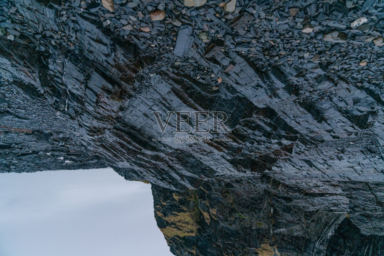 岩层——经过数百年的堆积形成的五颜六色的岩石，质地粗糙。石头的纹理和背景。海滩上堆积的岩石和巨石照片摄影图片