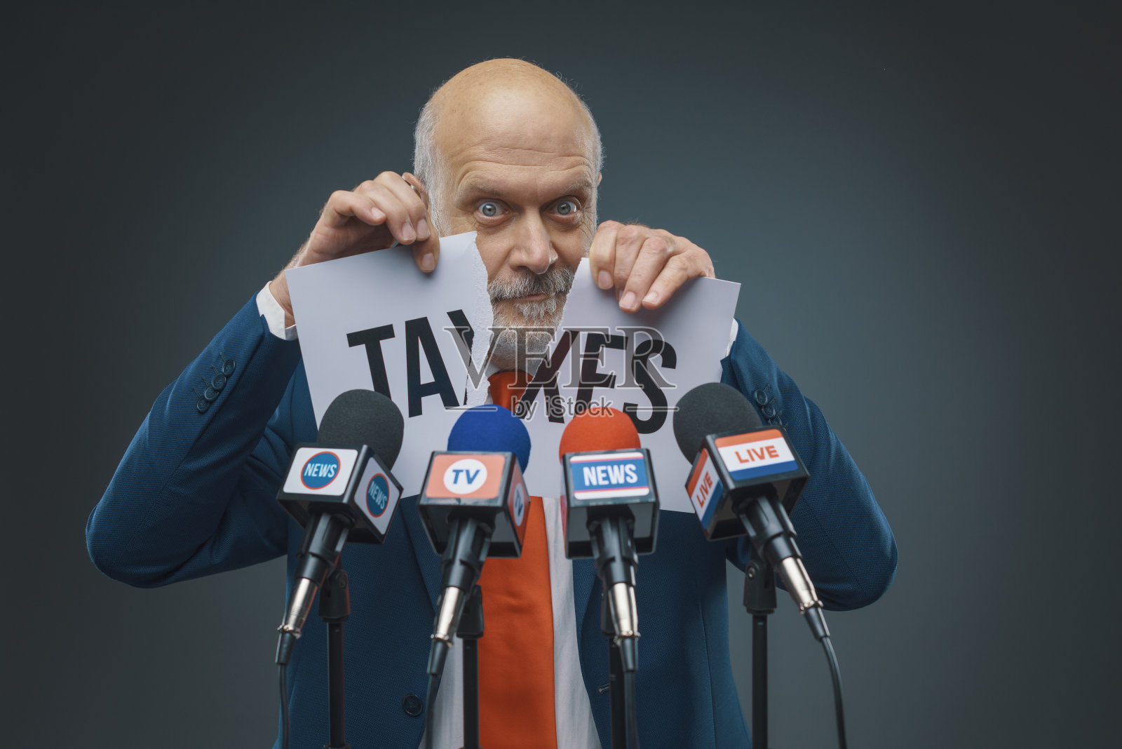 政客撕扯着带有税收概念的标志照片摄影图片