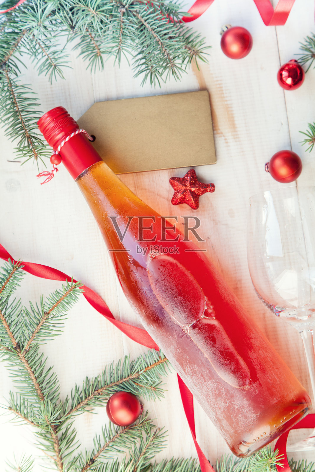 背景里有一个木箱子，里面放着一瓶白葡萄酒，一棵圣诞树，还有一个装着礼物的玻璃杯照片摄影图片