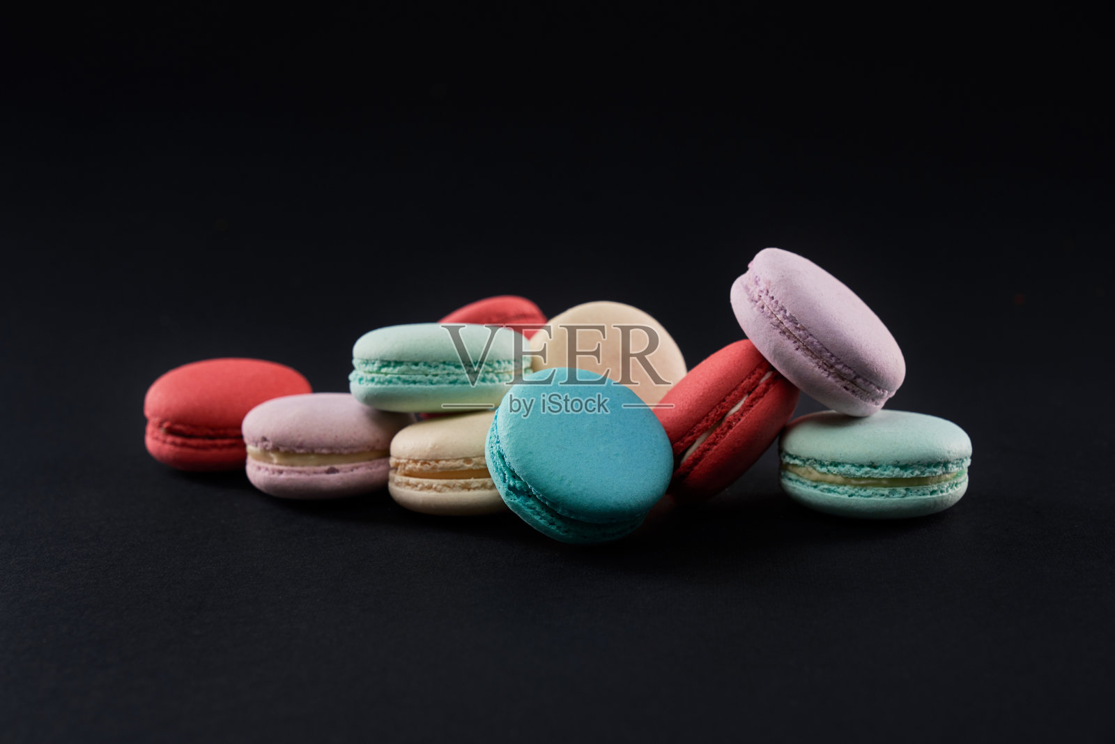 彩色的杏仁饼排在黑色孤立。照片摄影图片