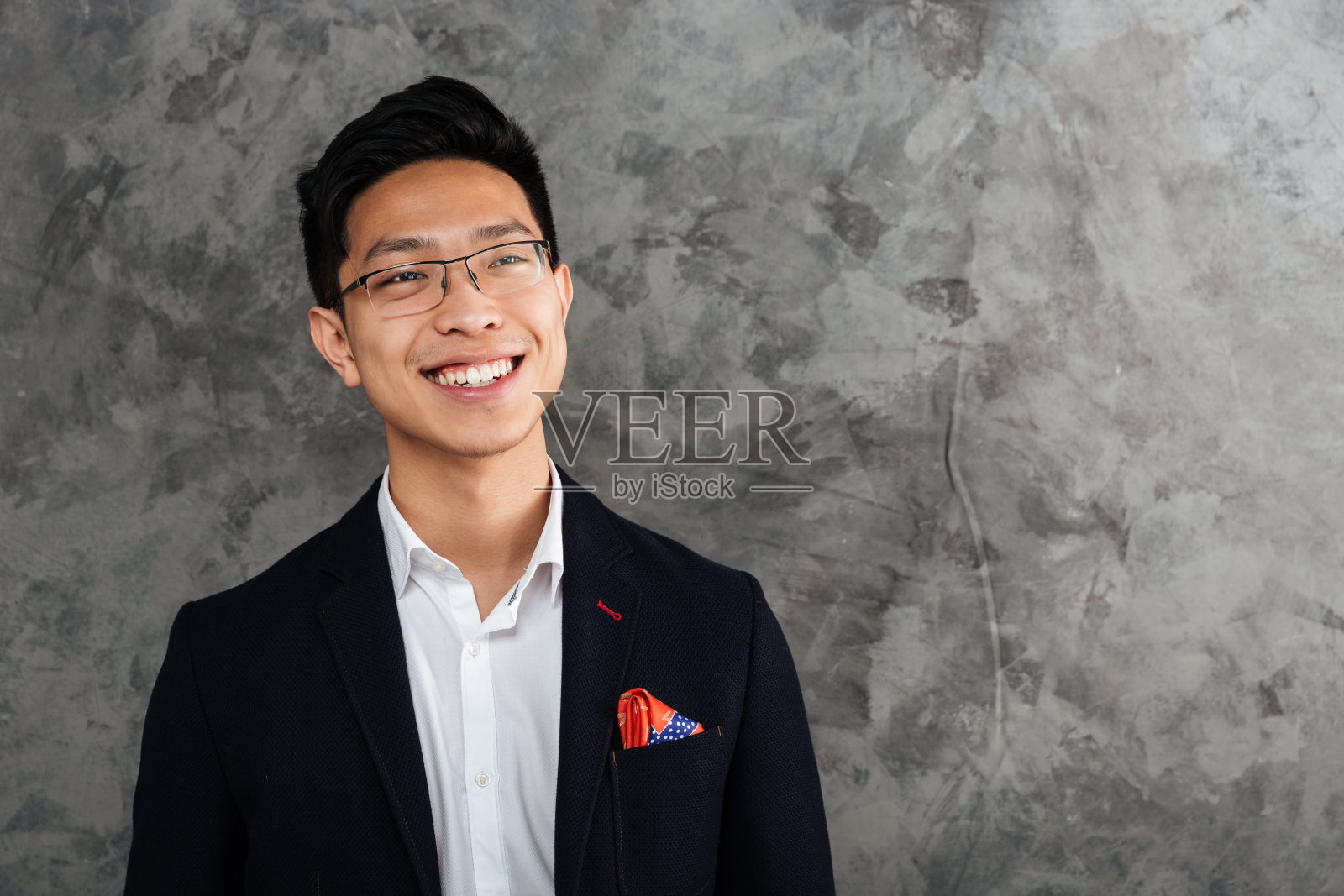 一个微笑的亚洲人的肖像穿着西装看着别处照片摄影图片