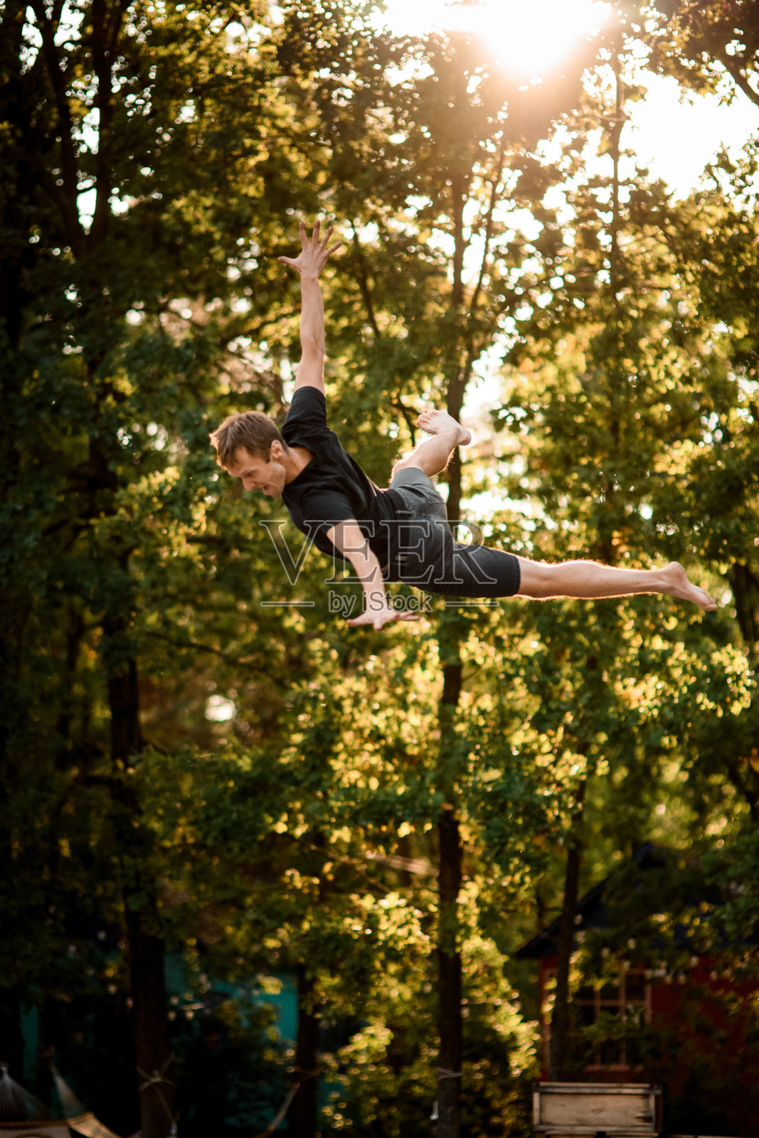 男子在蹦床上弹跳并在空中表演特技照片摄影图片