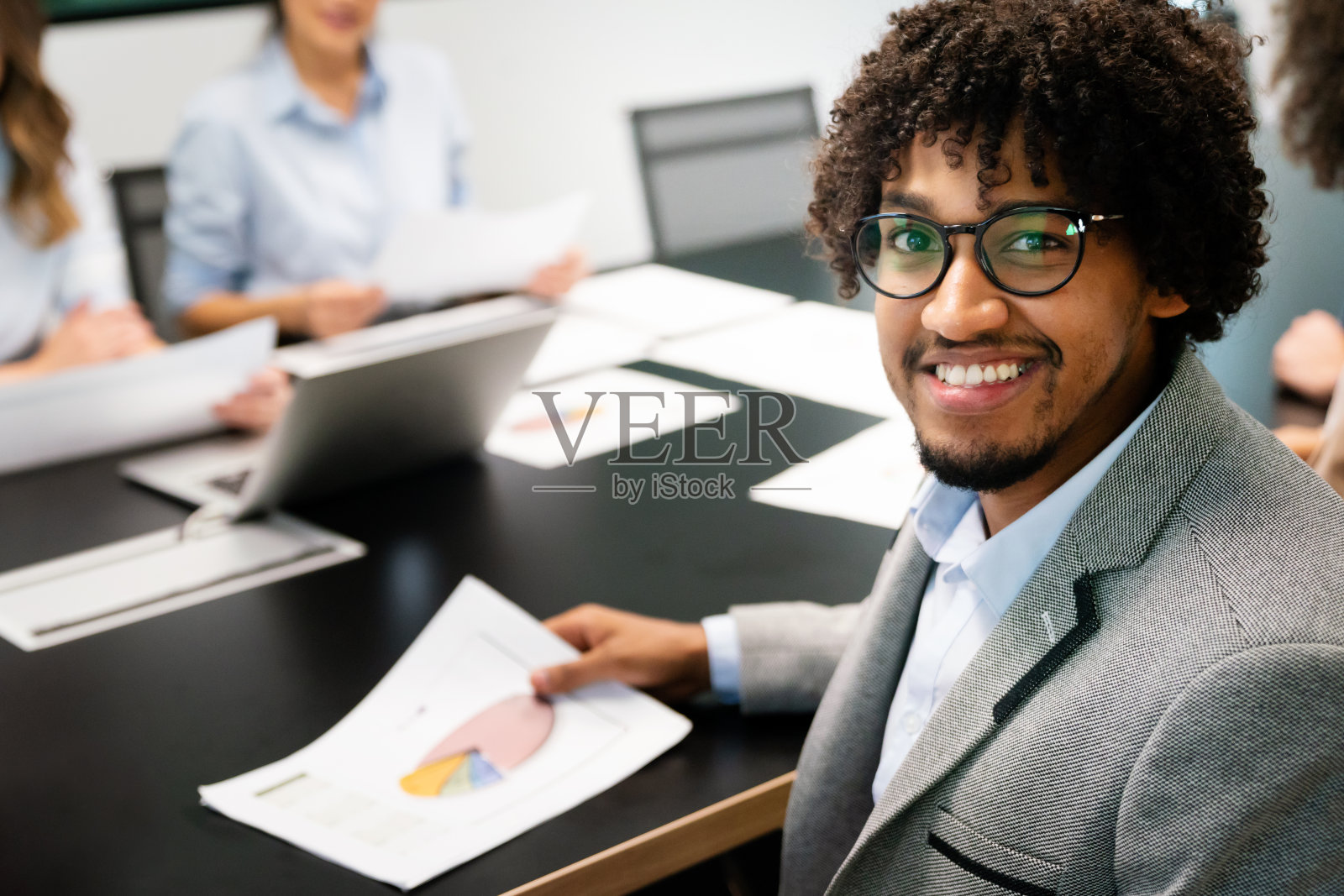 快乐的商人与同事在办公室开会照片摄影图片