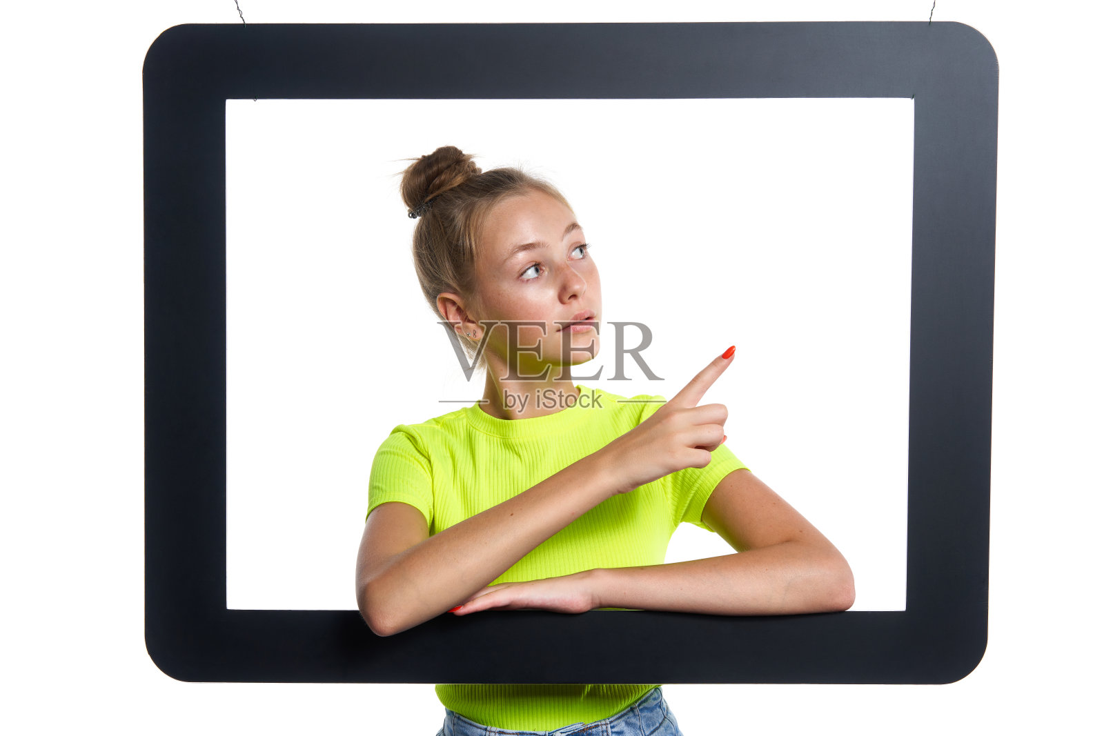 十几岁的女孩看通过数字平板电脑框架指向一边照片摄影图片