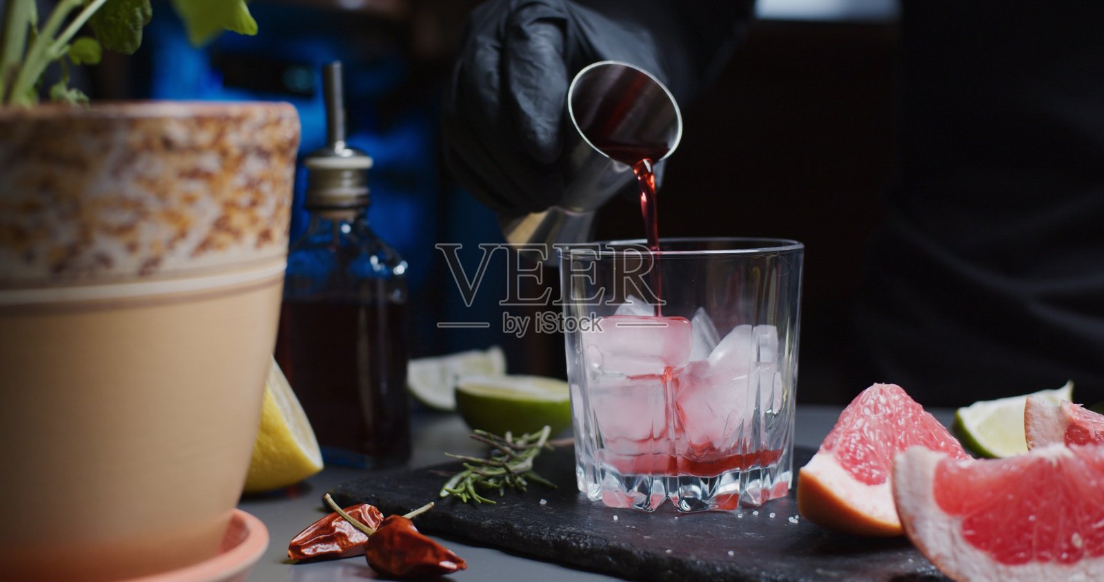 人类的双手正在用各种柑橘类果汁和迷迭香调制鸡尾酒照片摄影图片