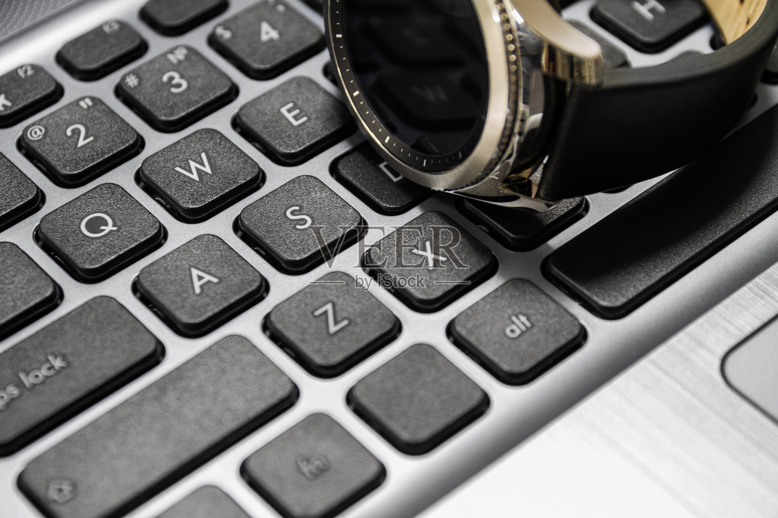 现代智能手表在笔记本电脑上。特写镜头,有选择性的重点照片摄影图片