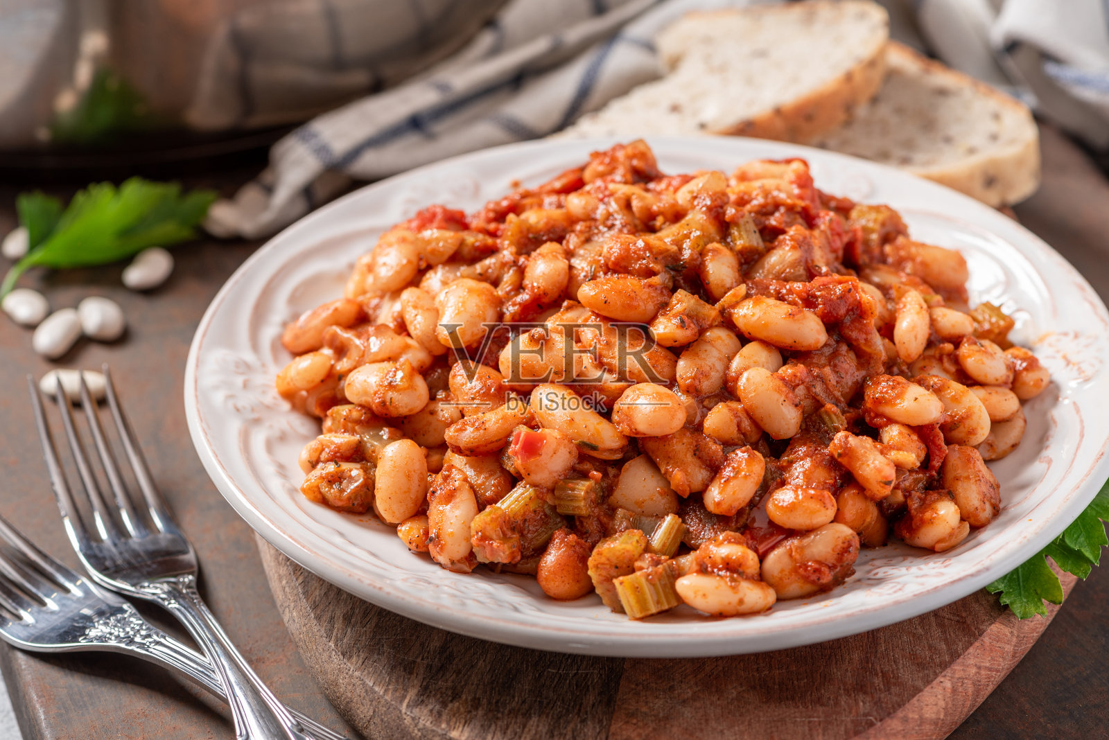 白豆配辣酱在白色陶瓷盘子里特写。照片摄影图片