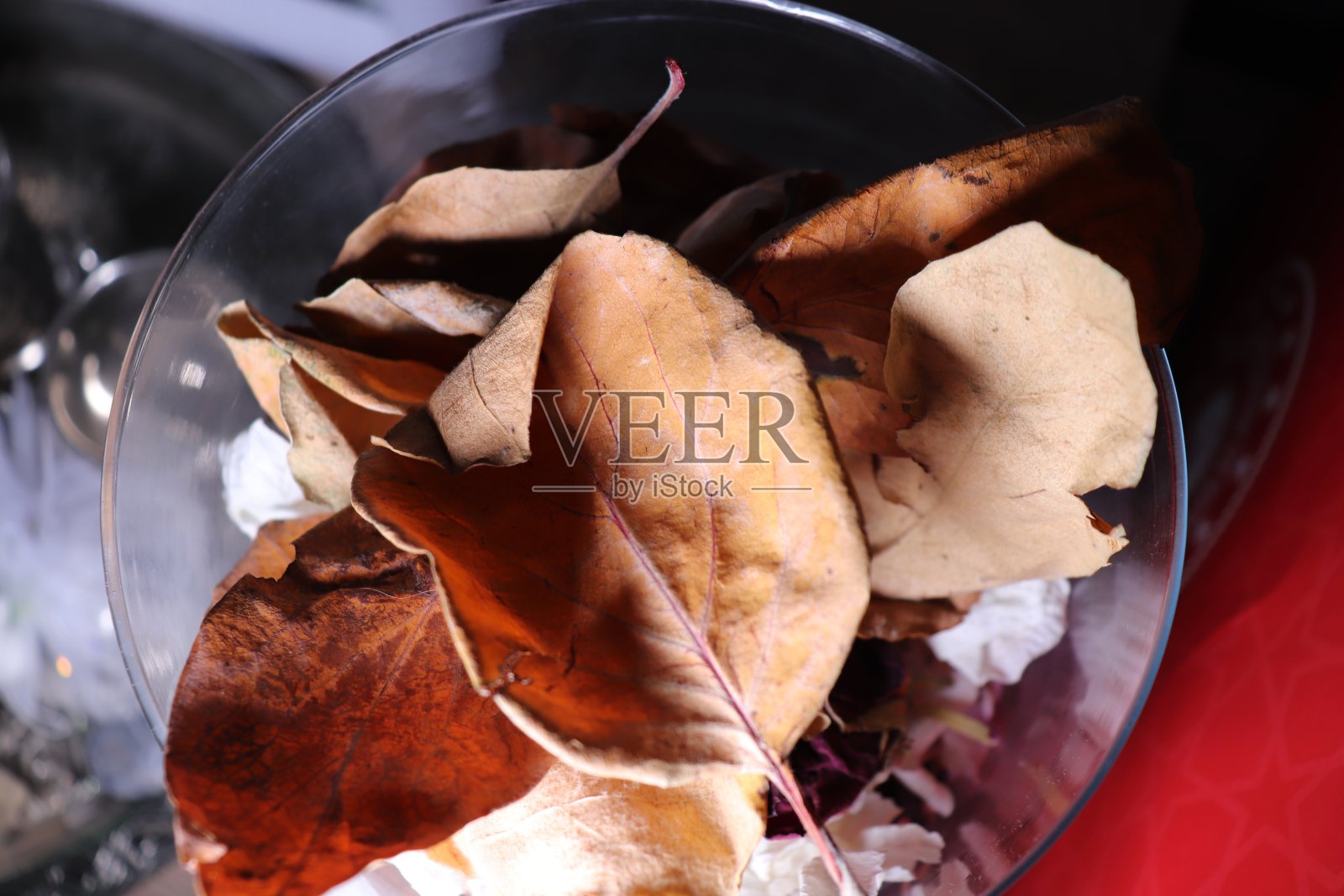 黄色的叶子在碗里，五颜六色的背景照片摄影图片