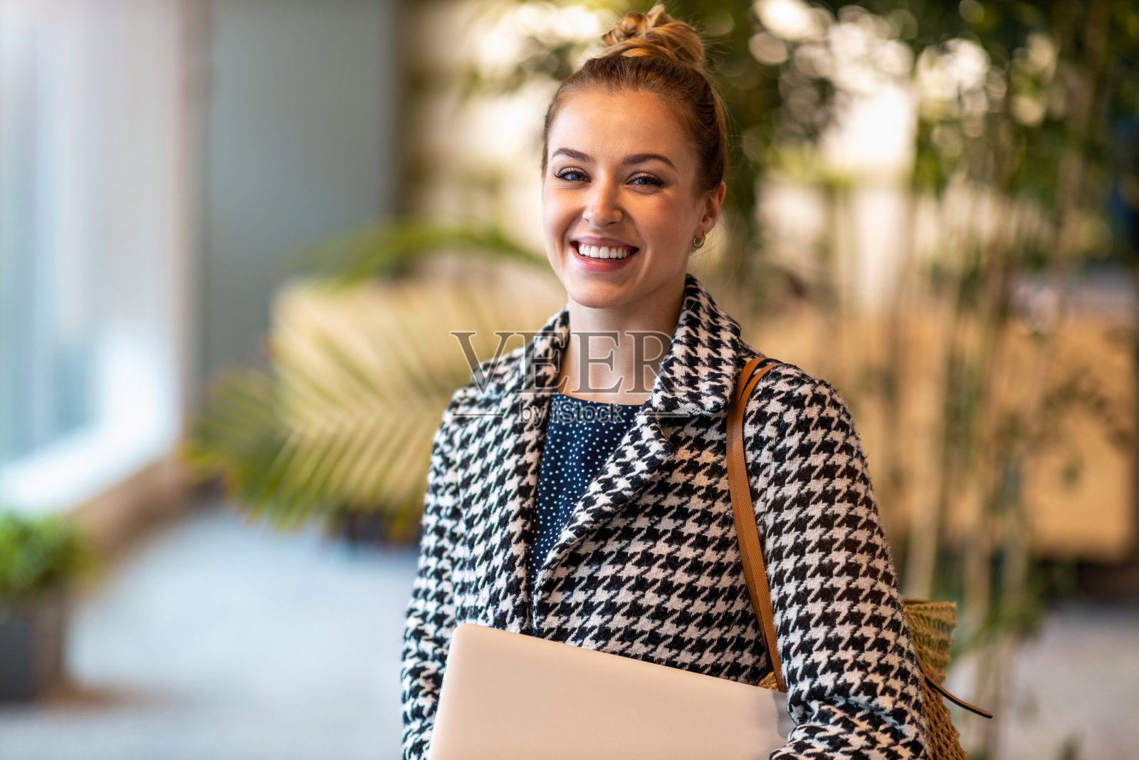 一个微笑的年轻女商人在现代办公室的肖像照片摄影图片