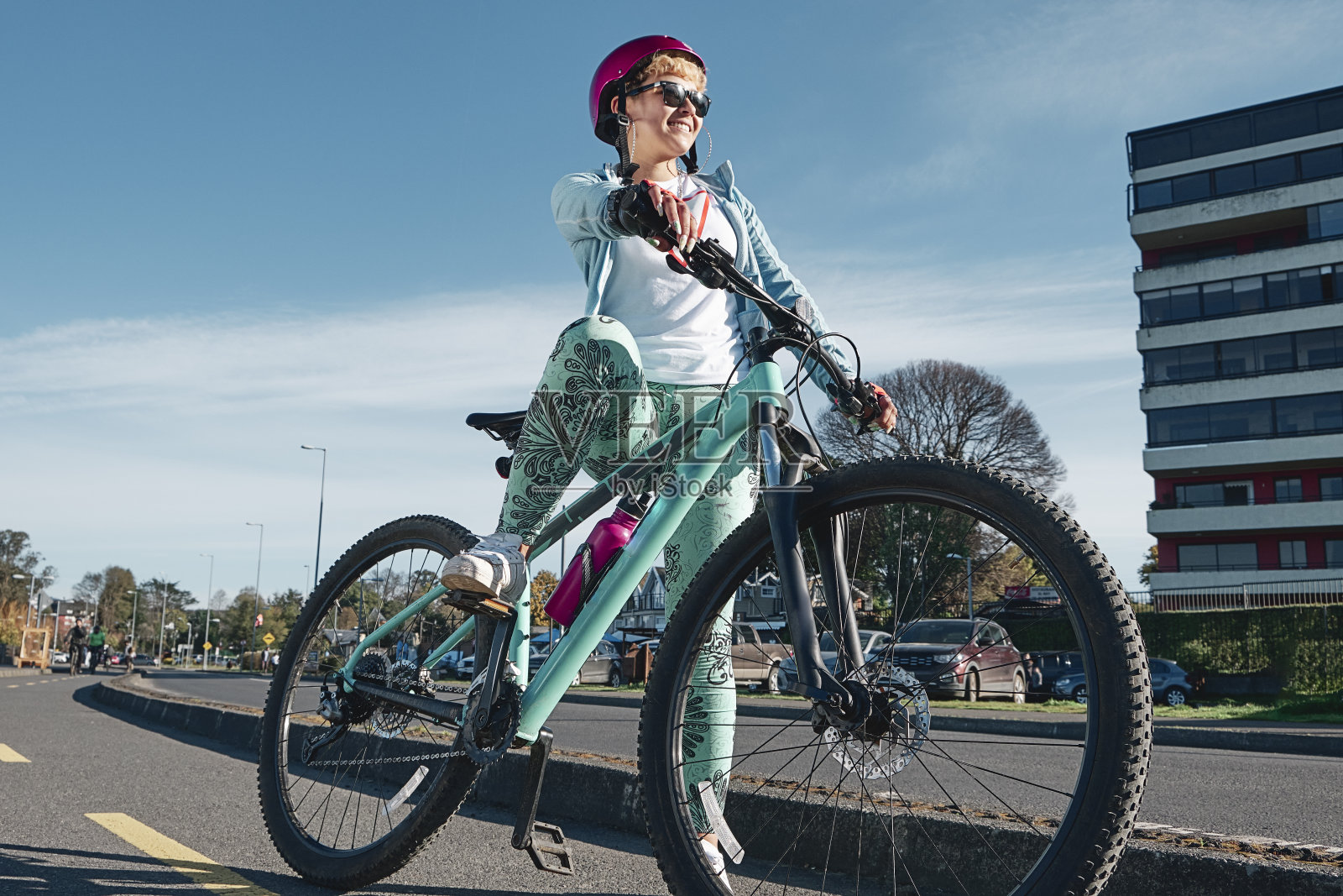 女孩骑自行车附近的主要街道与城市的背景。照片摄影图片
