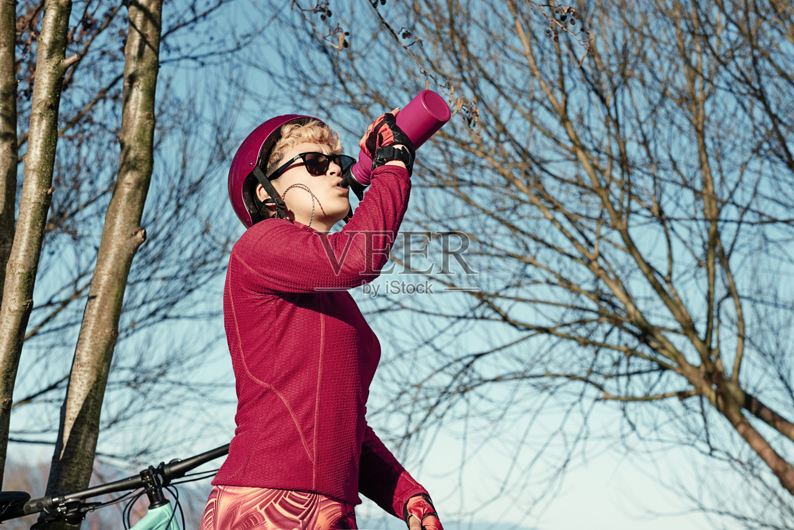 年轻的女运动员正在喝运动瓶里的水照片摄影图片