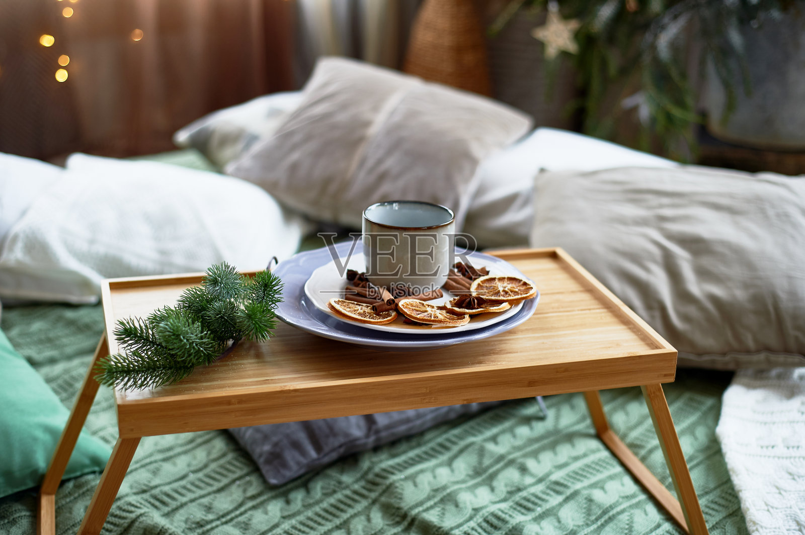 房子里舒适的冬季气氛，拥抱的风格。潘帕斯草，很多枕头和格子呢。早餐托盘照片摄影图片